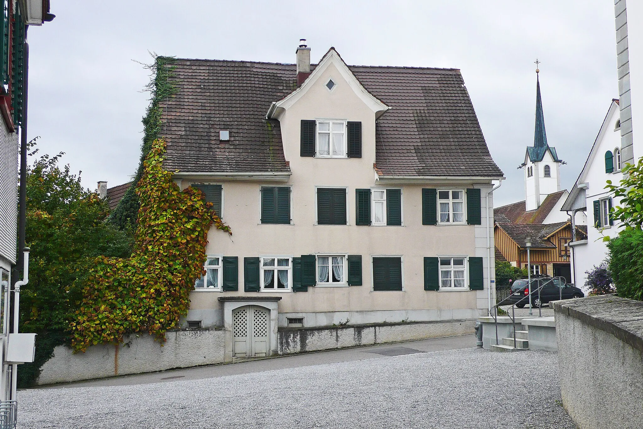 Photo showing: House and catholic church in Altnau, Switzerland.