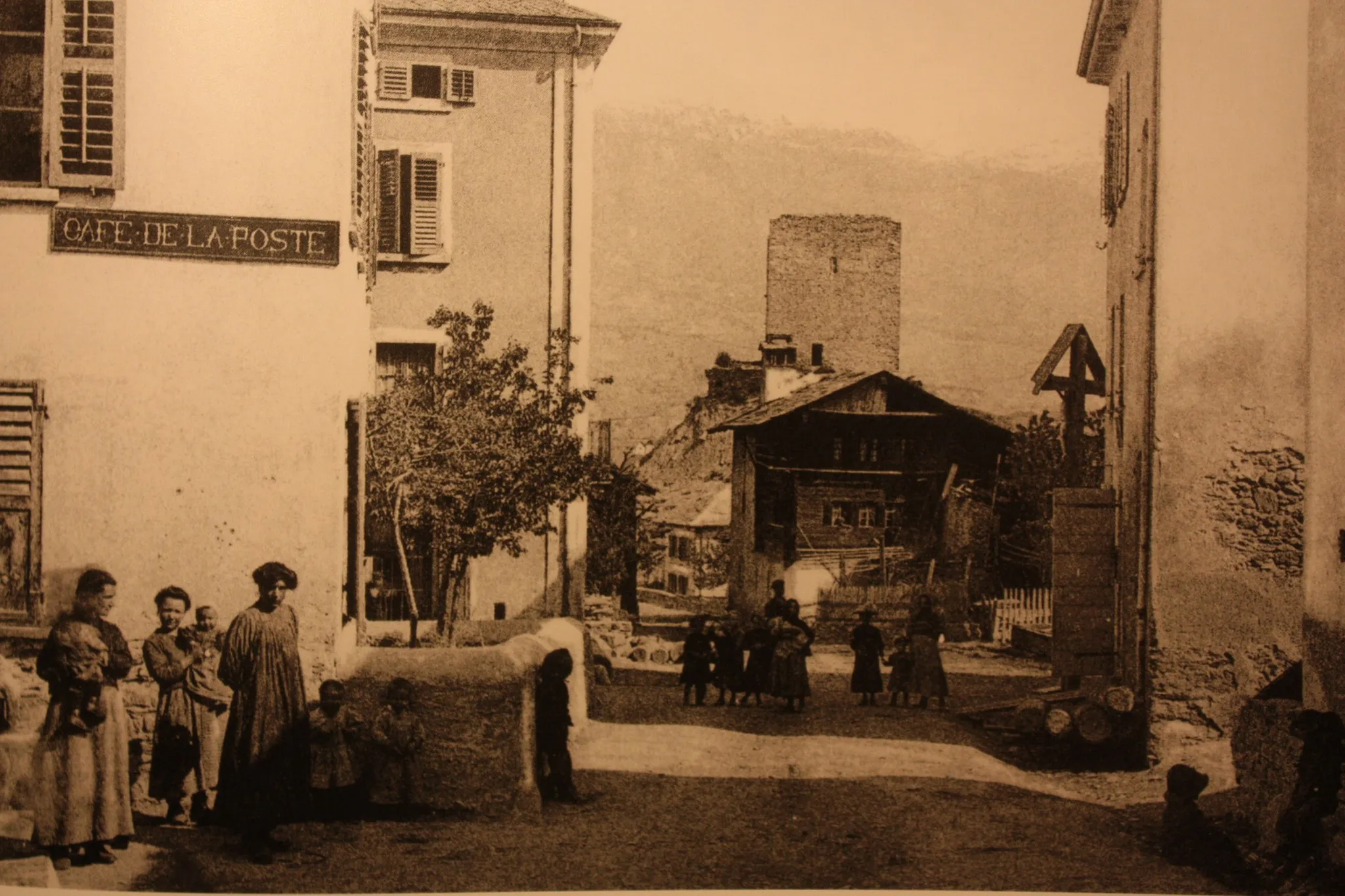 Photo showing: Rue de la Poste à Chalais (Suisse) en 1927, avec en arrière-plan la tour de Chalais avant l'effondrement du plan nord de celle-ci en 1936.