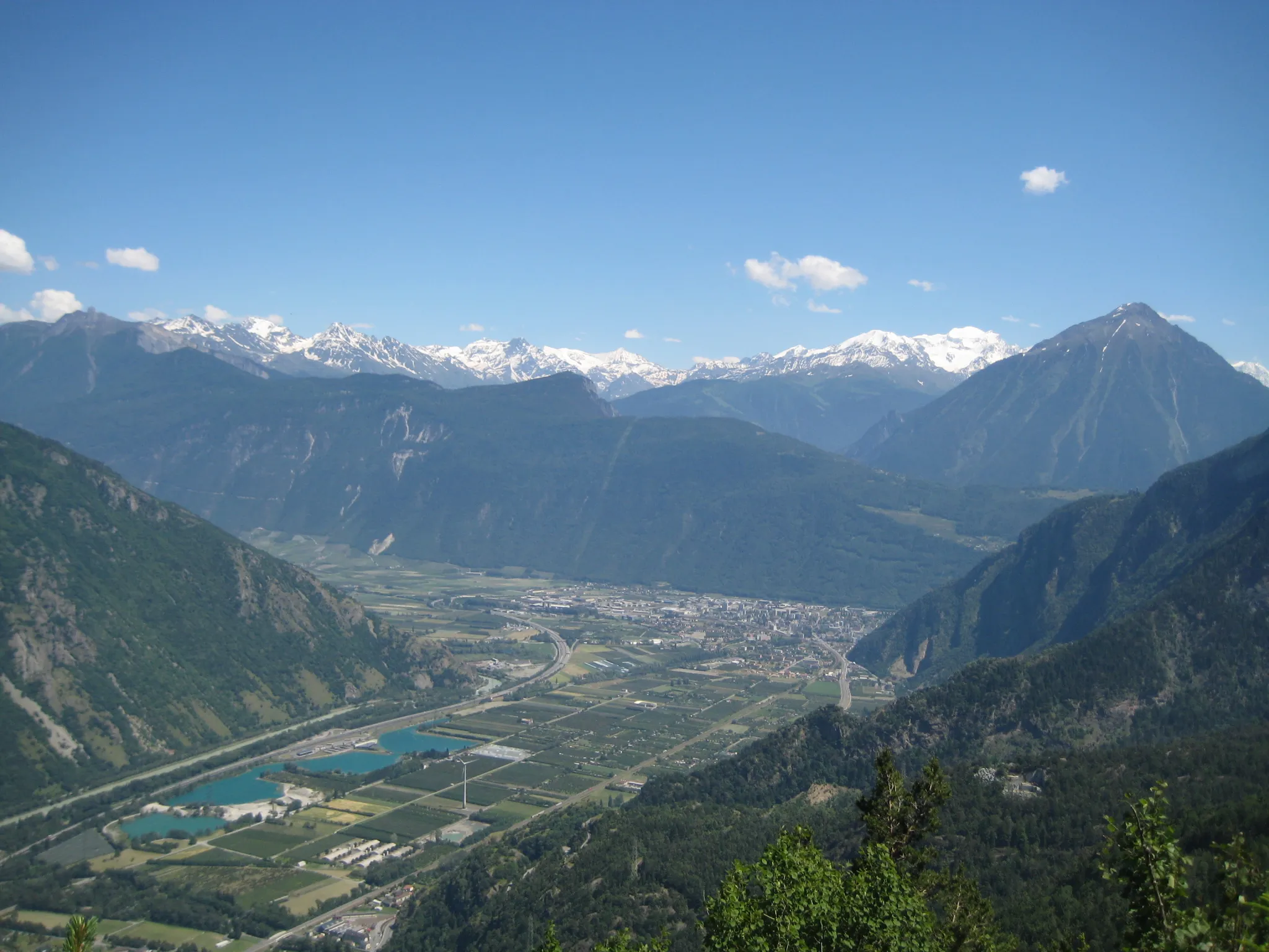 Photo showing: The rhone valley makes a sharp turn to the north-west in Martigny.
Catogne on the right

the somewhat lonesome wind turbine of Vernayaz can be seen on the right of the lakes