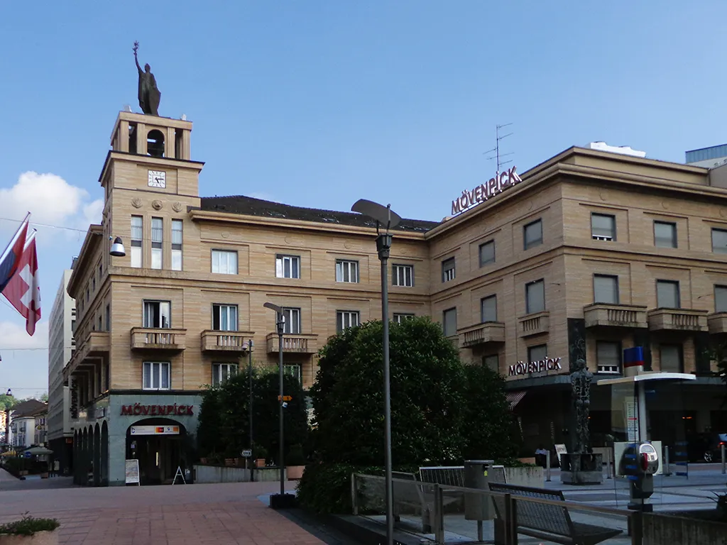 Photo showing: Palazzo Chiesa a Chiasso, comprendente l'Hotel Touring. Fu costruito dal 1936 al 1939 in stile "Novecento" su progetto di Americo Marazzi (come riportato da un pannello informativo).