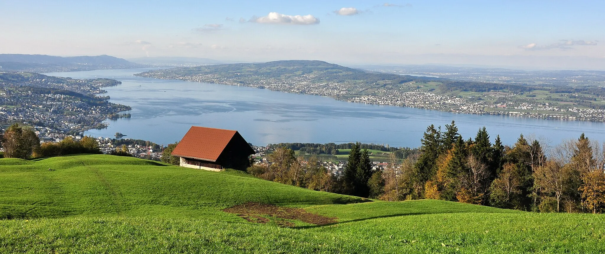 Photo showing: View from the Etzel mountain in Switzerland towards Etzel Kulm – focus on Pfannenstiel mountain : Richterswil (from the left side) on the Zimmerberg plateau, Albis chain with Felsenegg and Uetliberg, Zürich in the far background, Zürichsee, Greifensee (partially), Pfannenstiel plateau, Greifensee (partially) and Glatttal valley, Wollerau in the foreground.