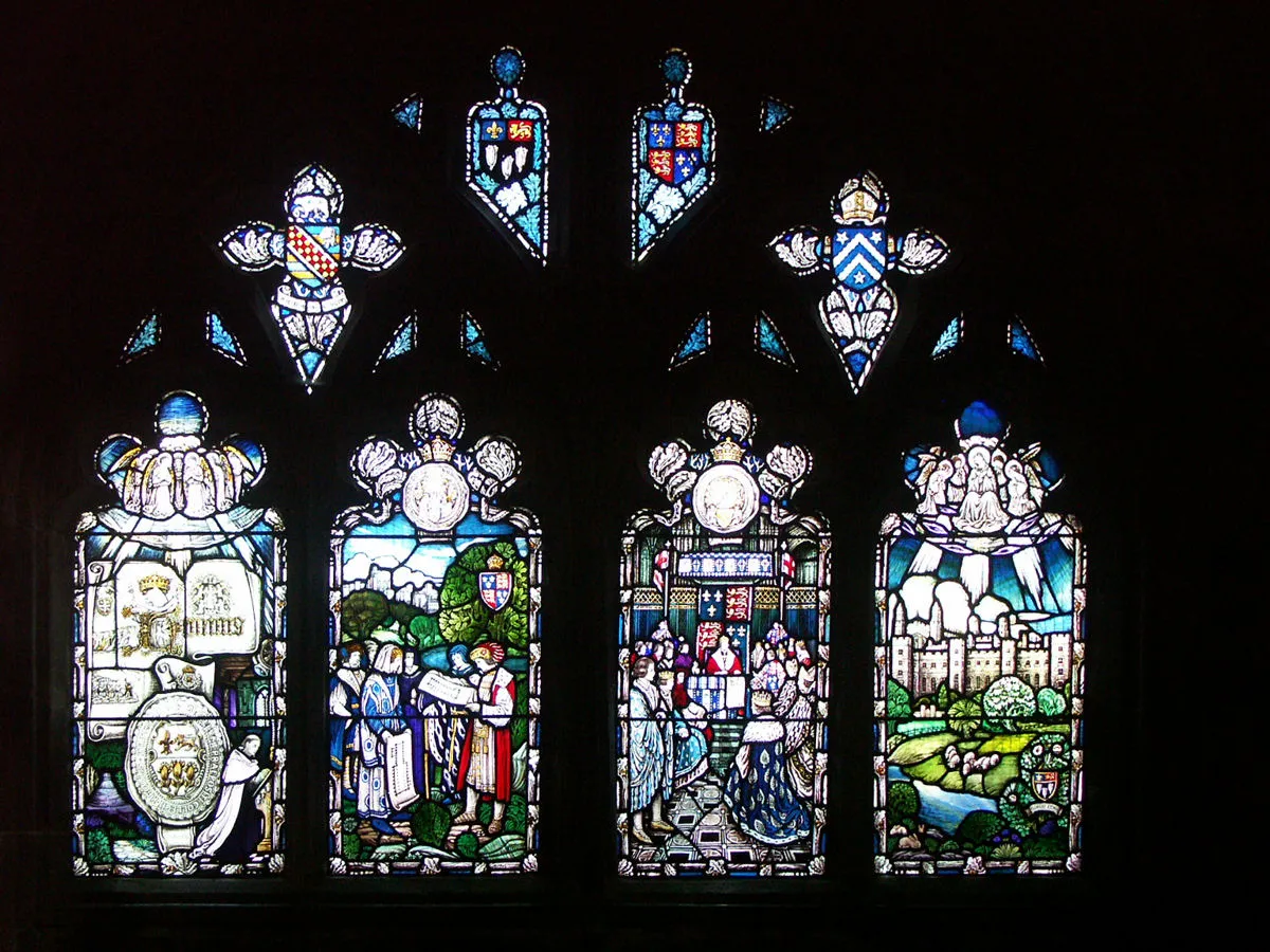 Photo showing: Hereford Cathedral, England. This window appears to show the founding of Eton College (by King Henry VI), on the banks of the River Thames in the shadow of Windsor Castle. Eton College Chapel is visible. The arms of Eton College are shown three times, together with the royal arms. Seal of Eton College at left, as in arms.
Text per www.geograph.org, Julian P Guffogg[1]: "Glass in the Stanbury Chapel, designed by Archibald Davies, given in 1923.
The windows depict scenes from the life of John Stanbury, confessor to King Henry VI and Bishop of Hereford in 1453. He assisted the King in his plans for Eton College and this is depicted in the windows.

The left hand light shows Angels around a lamp, above a book symbolising the spirit of learning. The next light shows the Bishop planning the College with Henry VI and Windsor Castle in the background. The third light shows Henry VI granting a charter to the college. He is seated on a throne with his nobles in front of him. The final lights shows Eton College, with the River Thames and the Arms and motto of the college."