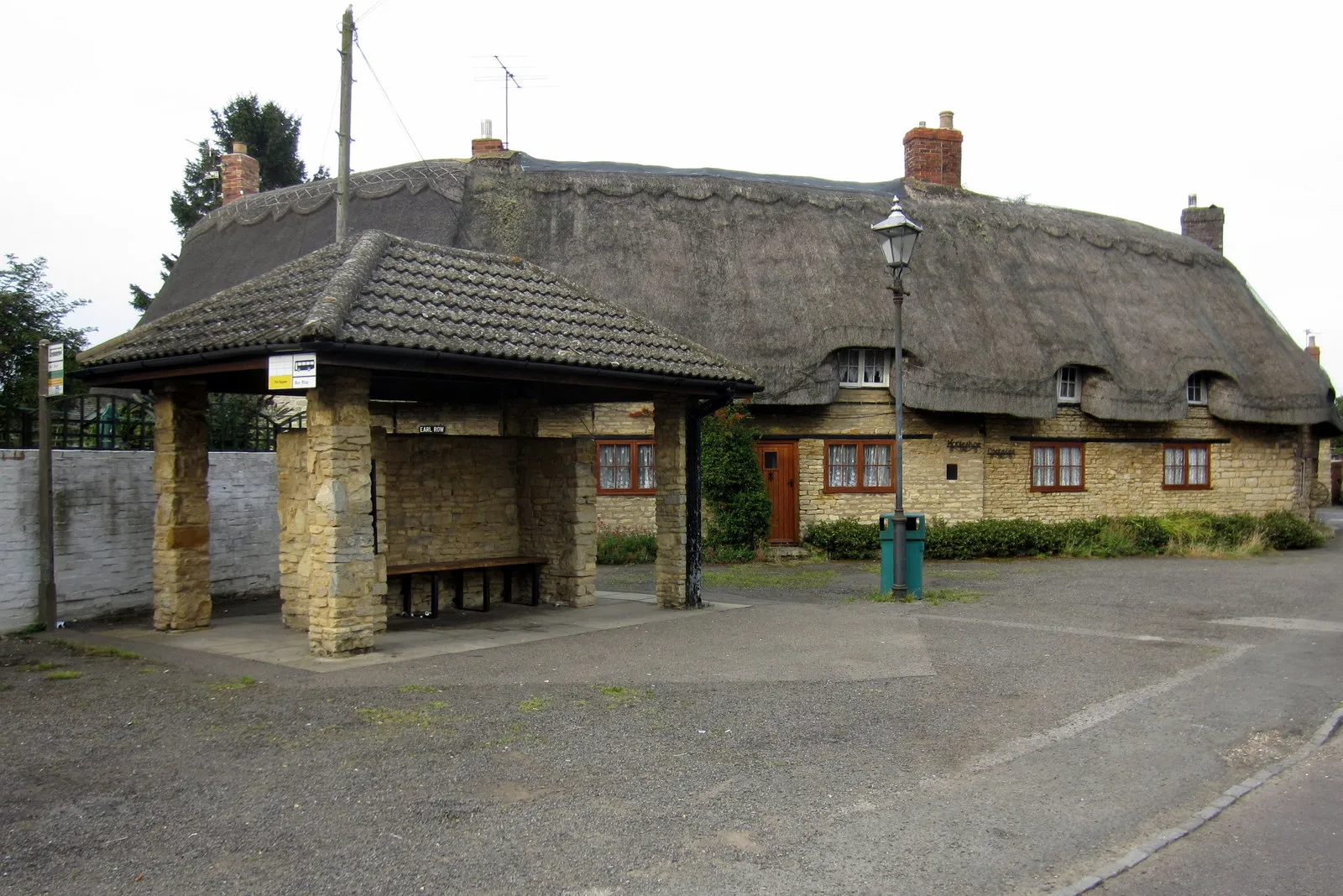 Photo showing: Bus shelter and cottages by the church