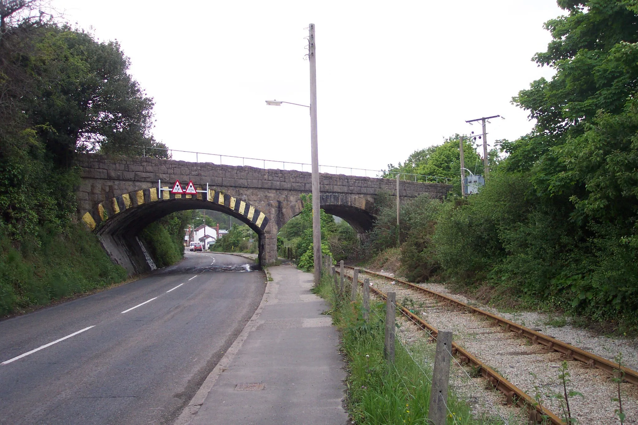 Photo showing: The line of the former Cornwall Minerals Railway passing under Par Viaduct and the line of the former Great Western Railway near the entrance to Par Harbour. For more information see the Wikipedia article Cornwall Minerals Railway.