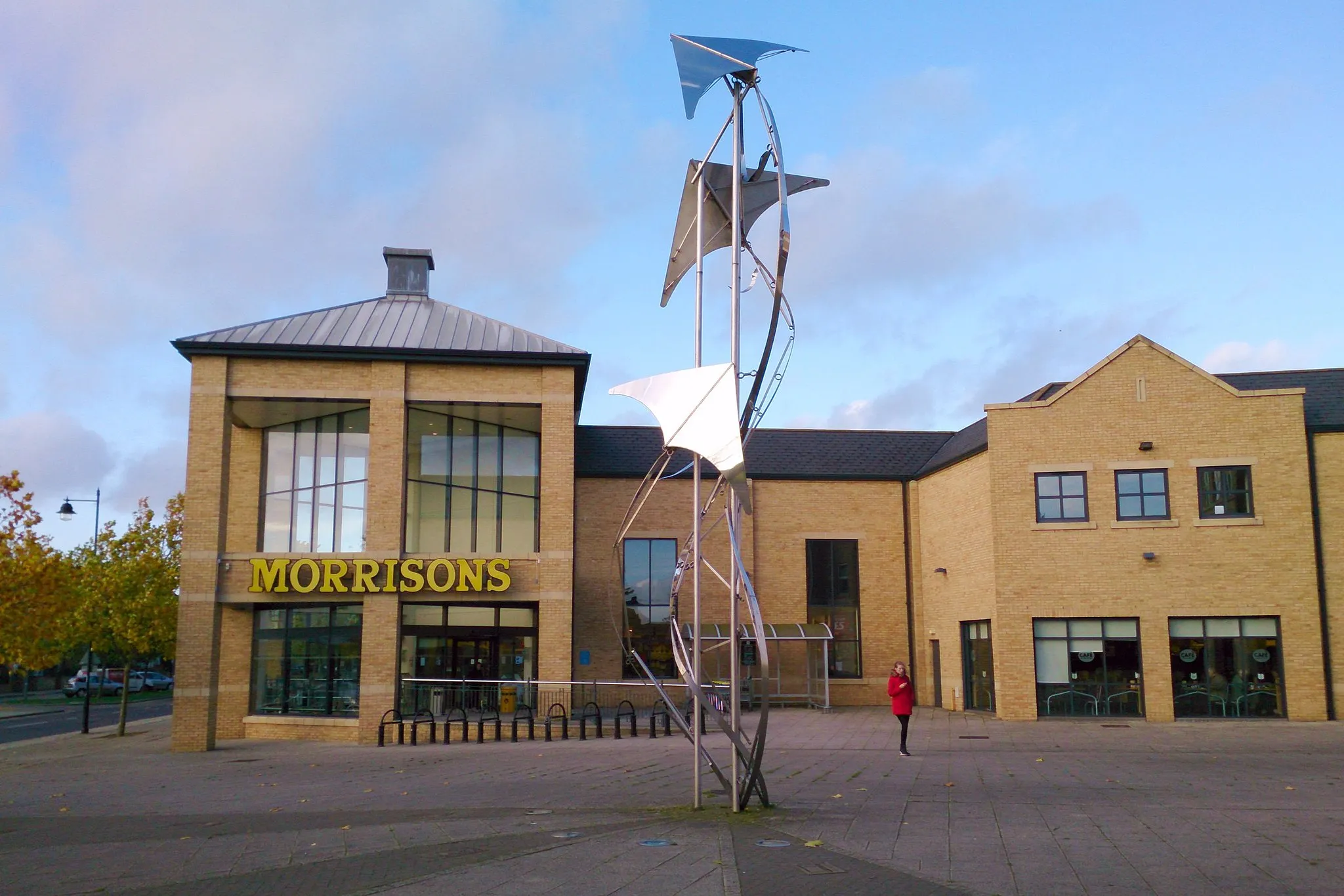 Photo showing: Cambourne Morrisons supermarket and Richard Thornton flight-themed sculpture commemorating the area's connections with the Royal Air Force and World War 2 aeroplane production.
