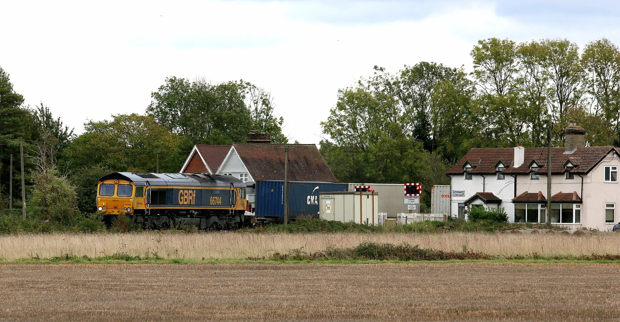 Photo showing: 4Z26 1313 Felixstowe North Gbrf to Masborough N&W GBRF running 20 mins early speeds sacross Fordham Level Crossing near newmarket with 66 744 "Crossrail" in charge.