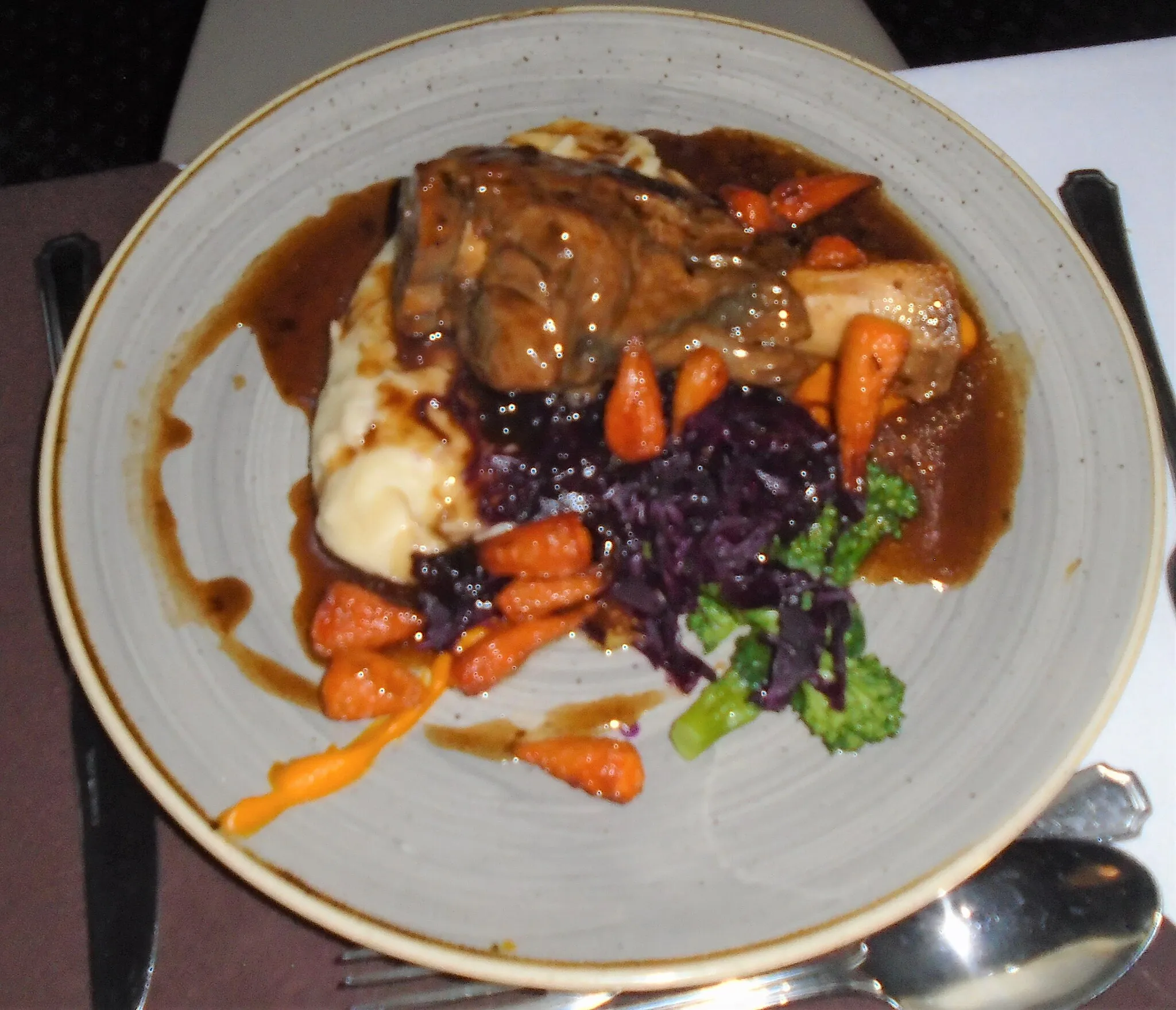 Photo showing: A slow pot roasted Norfolk lamb shank, buttered mash, braised red cabbage, honey roasted carrots, red currant jelly jus, served for dinner in the village of Trimingham, Norfolk, England.