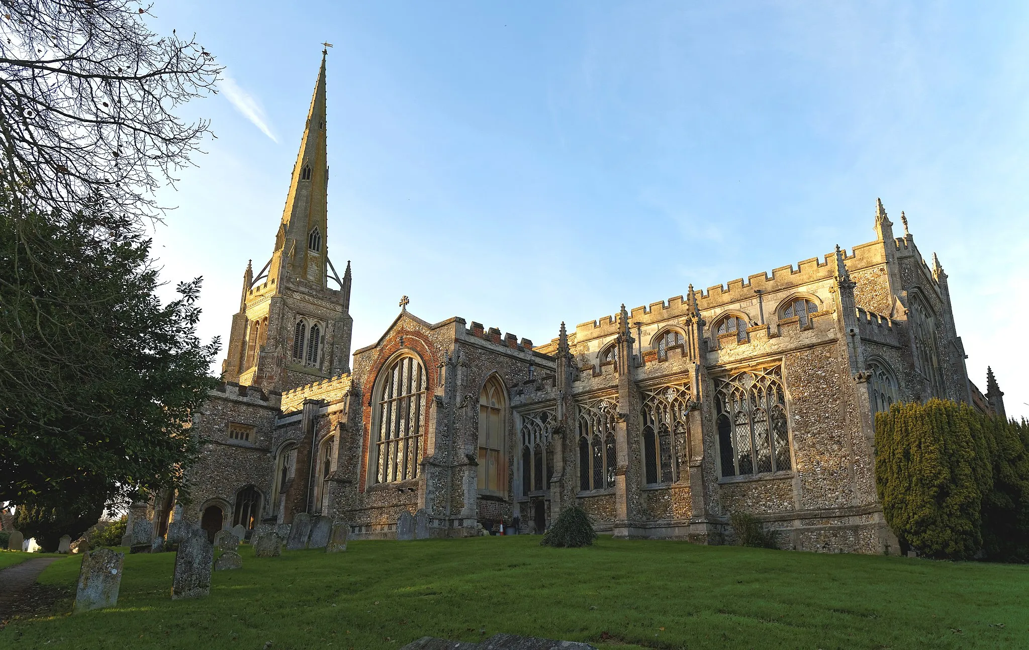 Photo showing: The south-east of the Church of St John the Baptist from the churchyard at Thaxted, Essex, England. Software: JPEG file optimized and/or cropped and/or spun with DxO OpticsPro 10 Elite and Adobe Photoshop CS2.