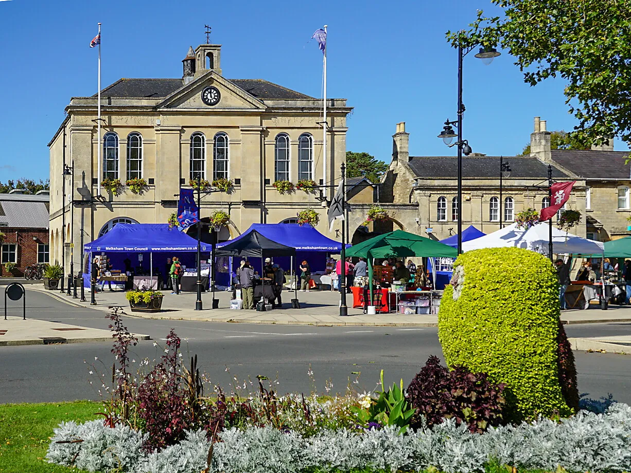 Photo showing: Melksham Makers' Market under way in front of the Town Hall, with a floral display in the foreground