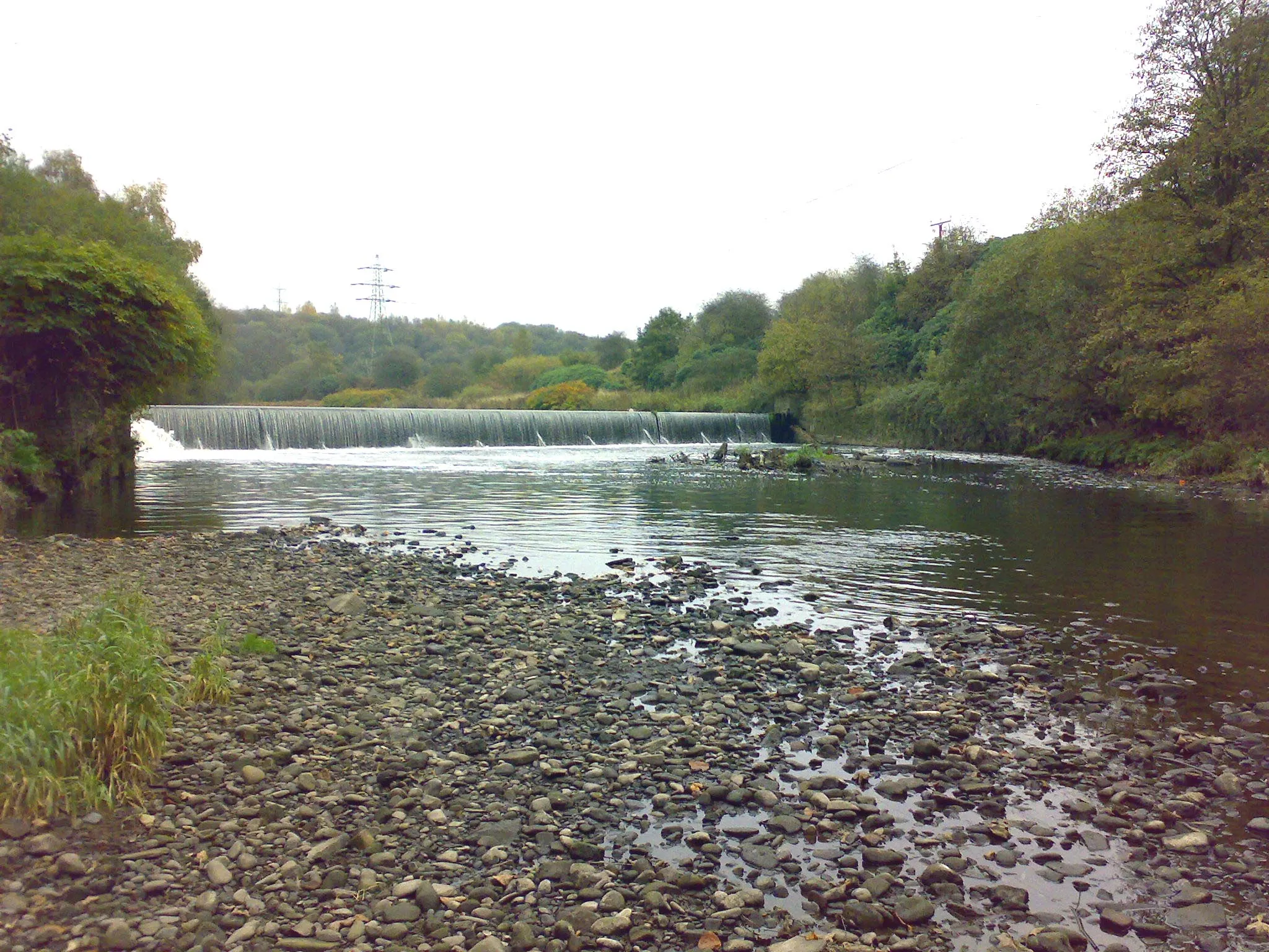 Photo showing: A weir at Ladyshore, on the Irwell.  Water was originally diverted to the left of the image (northwest) to Lever Bank Bleach Works.