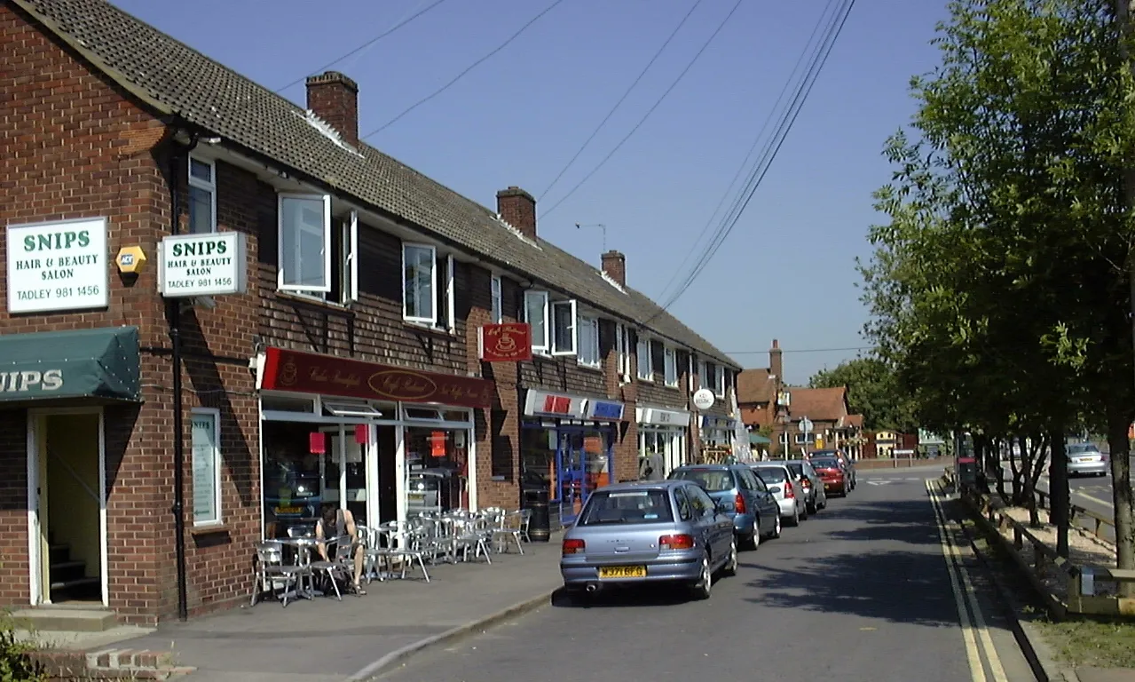 Photo showing: Shops on Mulfords Hill, Tadley, England, in part of the main shopping area in the town. The picture was taken under conditions of sun and clear sky at approximately 09:30 UTC. The equipment used was a Toshiba PDR-M1 digital camera in Auto mode. The original picture was cropped from the bottom to remove excess foreground.