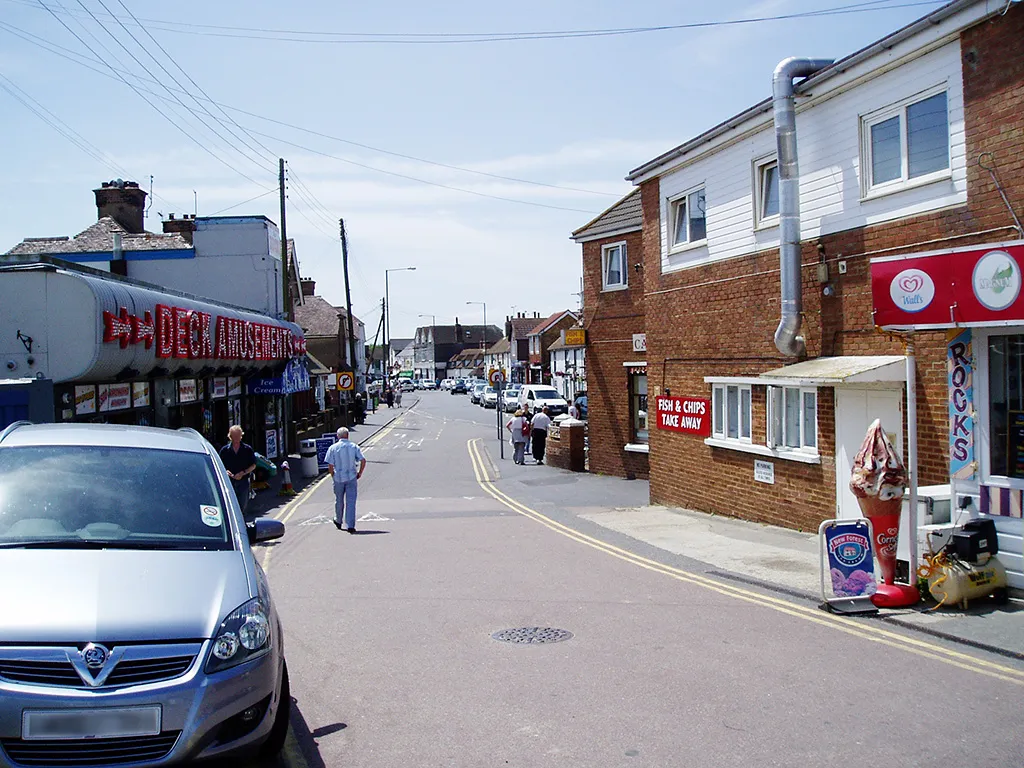 Photo showing: A view up the High Street in Dymchurch, Kent, UK, from the slipway road.