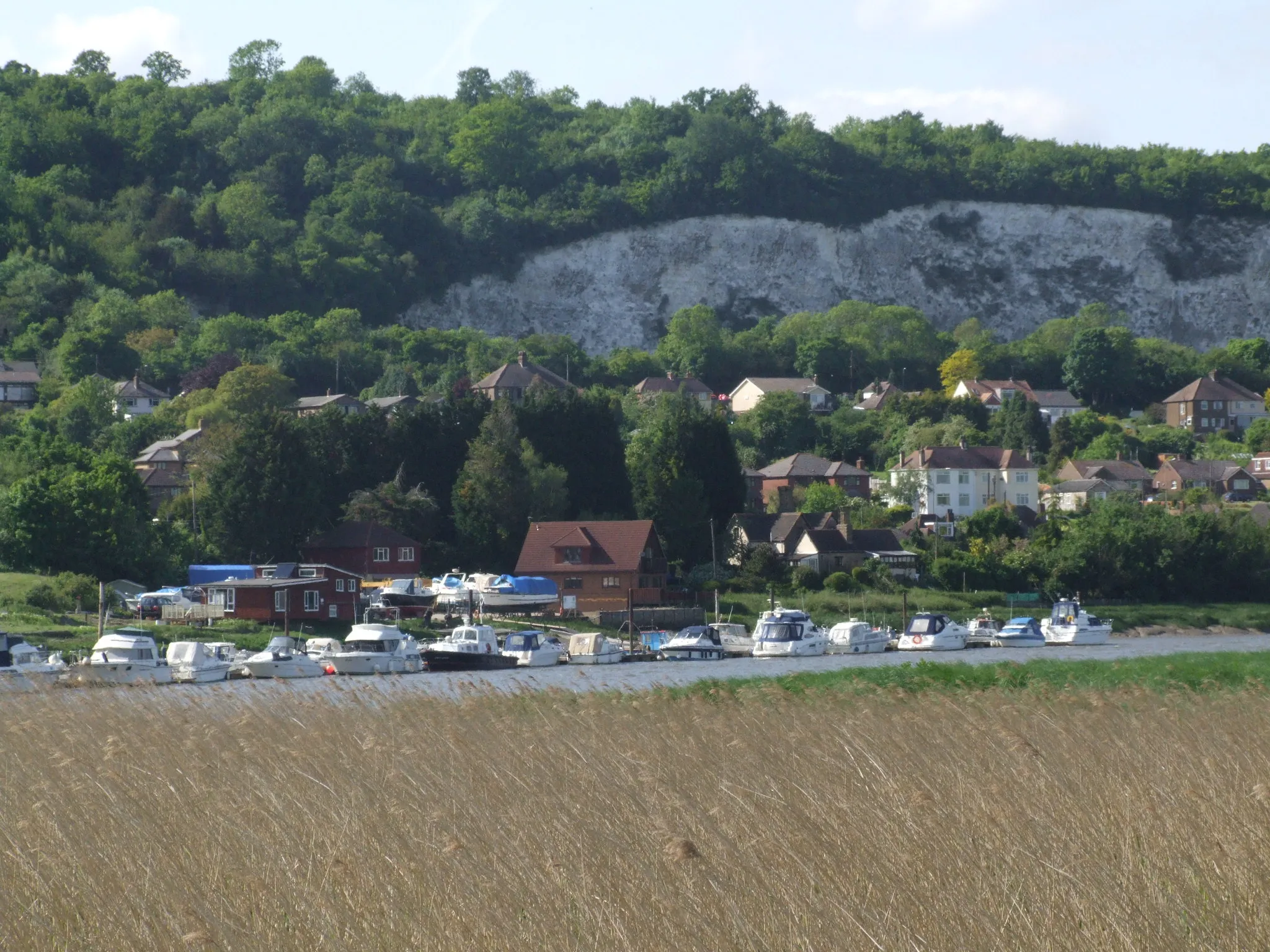 Photo showing: Halling, Kent on the River Medway.
From Wouldham Marshes, over the Medway to houses in North Halling, with cliffs of Bore's Hole and May Wood to the top left.

Camera location 51° 21′ 39.24″ N, 0° 27′ 04.68″ E View this and other nearby images on: OpenStreetMap 51.360900;    0.451300