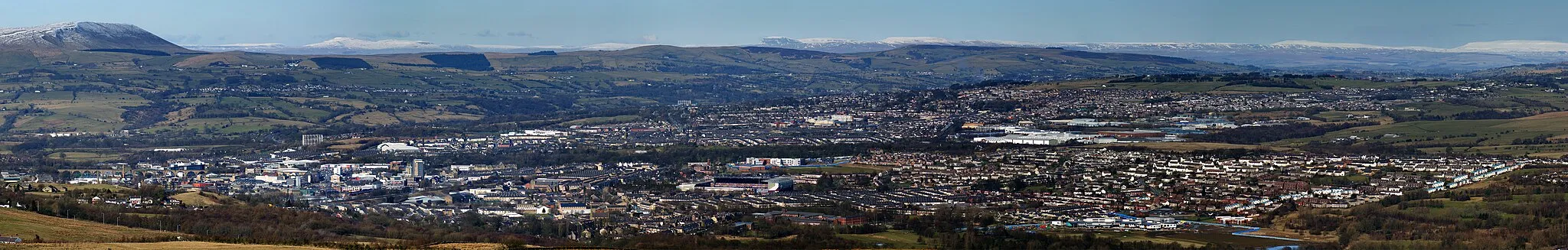 Photo showing: A panoramic image showing the town of Burnley from Crown point road. To the far top left of the image is the imposing Pendle Hill, with the Yorkshire Dales visible in the top central background. In the left of the image shows the town centre of Burnley and Turf Moor can be seen in the very centre of the picture. To the right the areas of Brunshaw and Pike Hill can be seen.