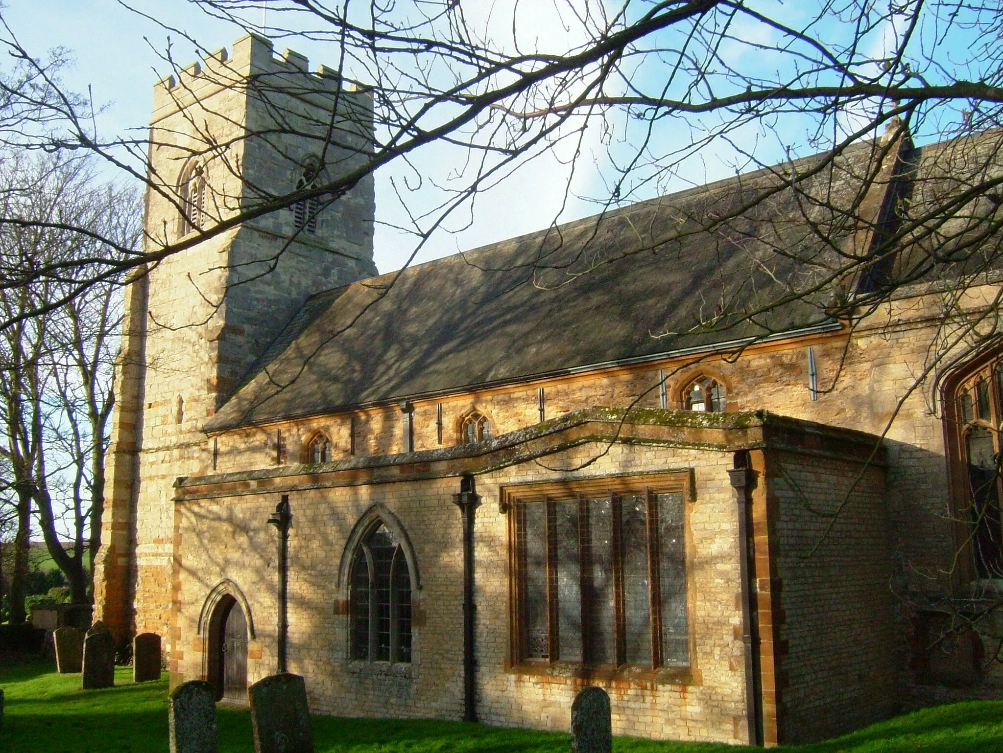 Photo showing: West tower, south aisle and clerestory of the parish church of St John the Baptist, Blisworth, Northamptonshire, England, seen from the southeast. The south aisle was added in 1926.