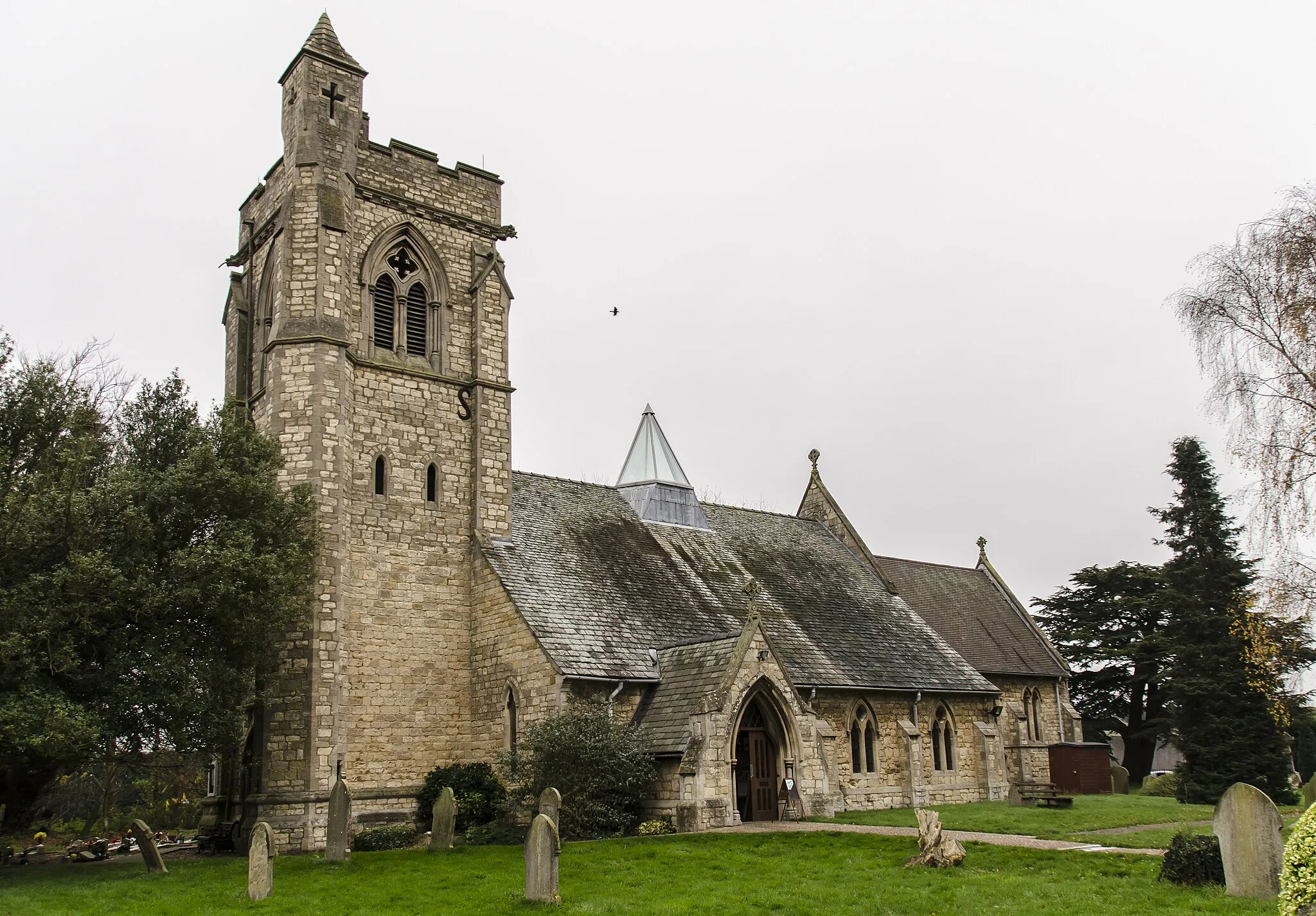 Photo showing: There has been a church on the site since the 13th century.
By 1854 the church was in a dilapidated condition and was rebuilt in 1855 by Hussey, using much of the old materials. There was a nave with clerestory, north and south aisles, and also a spire on the tower roof. The lower stages of the tower still contain some mediaeval masonry.
In 1916 there was a severe fire which left only the walls standing. Due to limited funds, only the chancel was given a permanent roof, the nave had a temporary roof which lasted nearly 80 years!
The spire was never rebuilt, and the aisle arcades replaced with brick and concrete ones.
The church was re-ordered in 1992 when the nave and aisle roofs, internal columns and pews were removed, and a new roof which spans the whole width of the church containing a glass lantern skylight.
Services are now held in the nave part of the church, with the chancel being used for the creche and for more intimate services.
There is a fine east window by Edward Payne.

The church now has a Kitchen, toilet and Wi-fi.