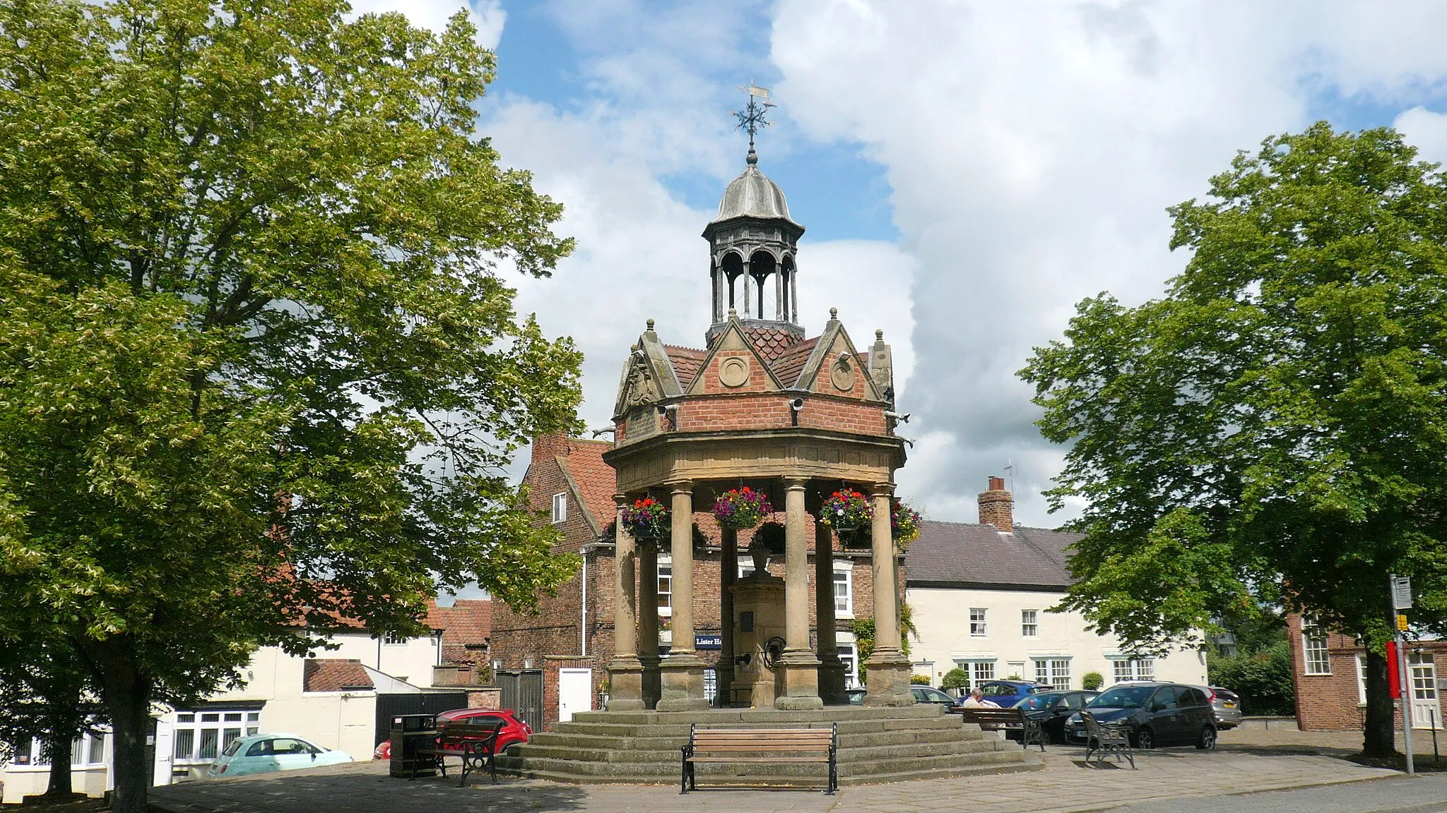 Photo showing: The cover over the 256-foot deep artesian well was built in 1875. It was gifted to the town by Mrs Lawson of Aldborough Manor in memory of her husband Andrew, who had died three years earlier. The extravagant canopy is one of the most ornate in England.