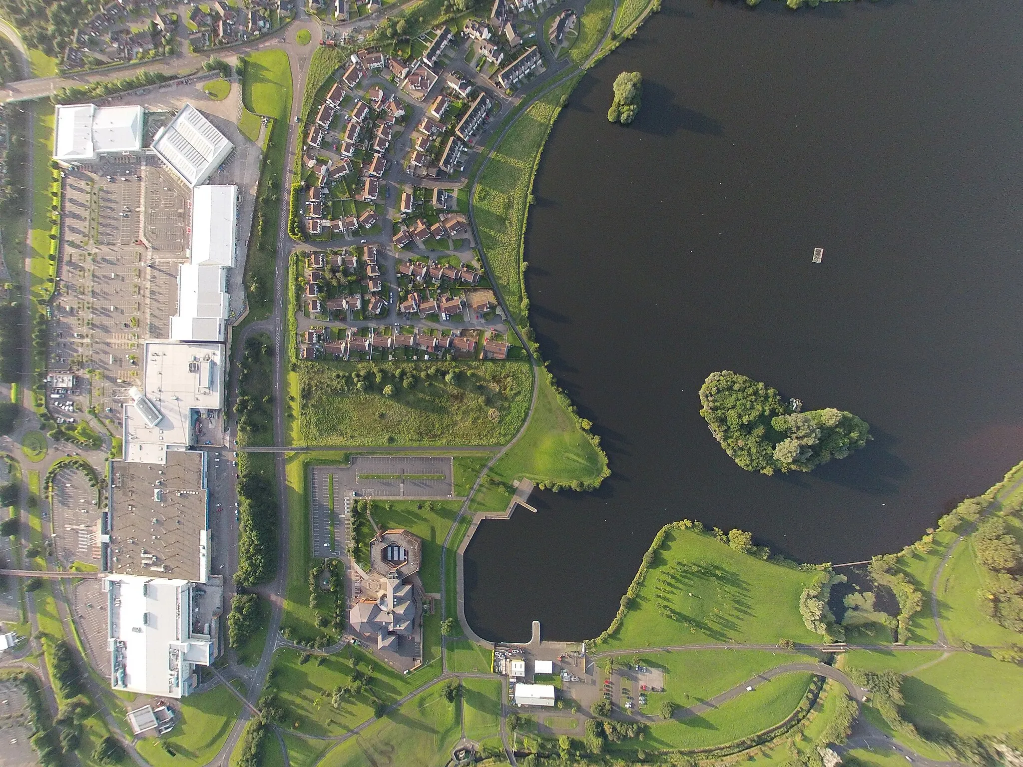 Photo showing: Aerial view of one of Craigavon lakes, Craigavon watersport center and Rushmere shopping centre, Craigavon civic centre and lakelands housing development from approx 1000ft