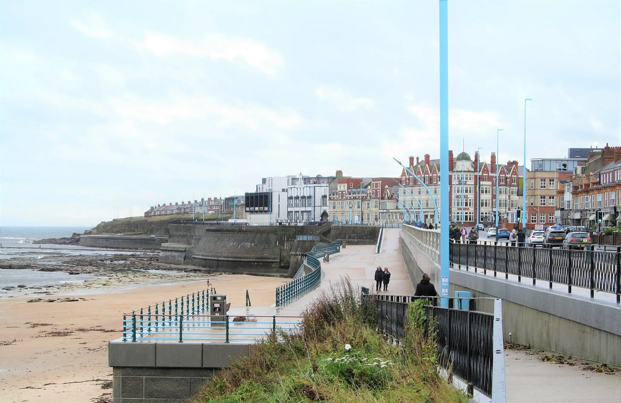 Photo showing: A few people braving the elements on an October day of high temperatures but also rain.