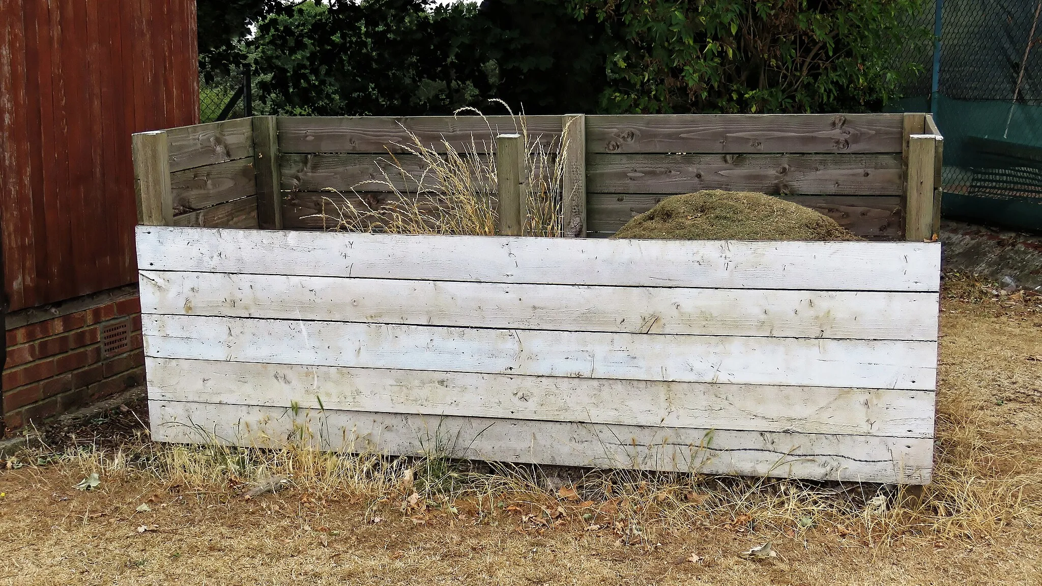 Photo showing: Compost bin at Wanstead and Snaresbrook Cricket Club, Wanstead, London. Mobile device view: Wikimedia (as at June 2022) makes it difficult to immediately view photo groups related to this image. To see its most relevant allied photos, click on this uploader's various. You can add a click-through 'categories' button to the very bottom of photo-pages you view by going to settings... three-bar icon top left. Desktop view: Wikimedia (as at June 2022) makes it difficult to immediately view the helpful category links where you can find images related to this one in a variety of ways; for these go to the very bottom of the page. This image is one of a series of date and/or subject allied consecutive photographs kept in progression or location by file name number and/or time marking. Camera: Canon PowerShot SX60 HS Software: File lens-corrected, optimized, perhaps cropped, with DxO PhotoLab 4 Elite, and likely further optimized with Adobe Photoshop CS2.