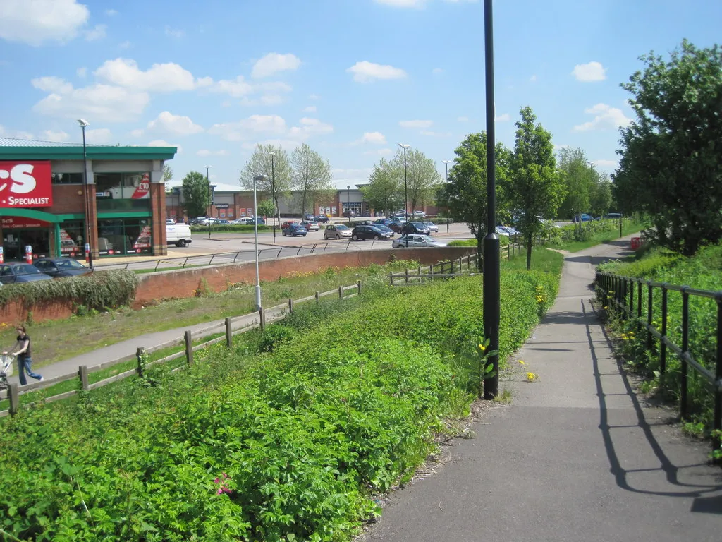 Photo showing: Doncaster York Road railway station (site) Although built to carry passengers, this short branch line apparently never did. Opened in 1916 jointly by the Hull & Barnsley Railway and the Great Central Railway, this ended up as a goods yard until the late 1960s when it closed. View south east from the side of (the new) York Road. The tracks crossed the car park, roughly left to right. The buffers would have been on what is now St Mary's roundabout, just out of view to the right.