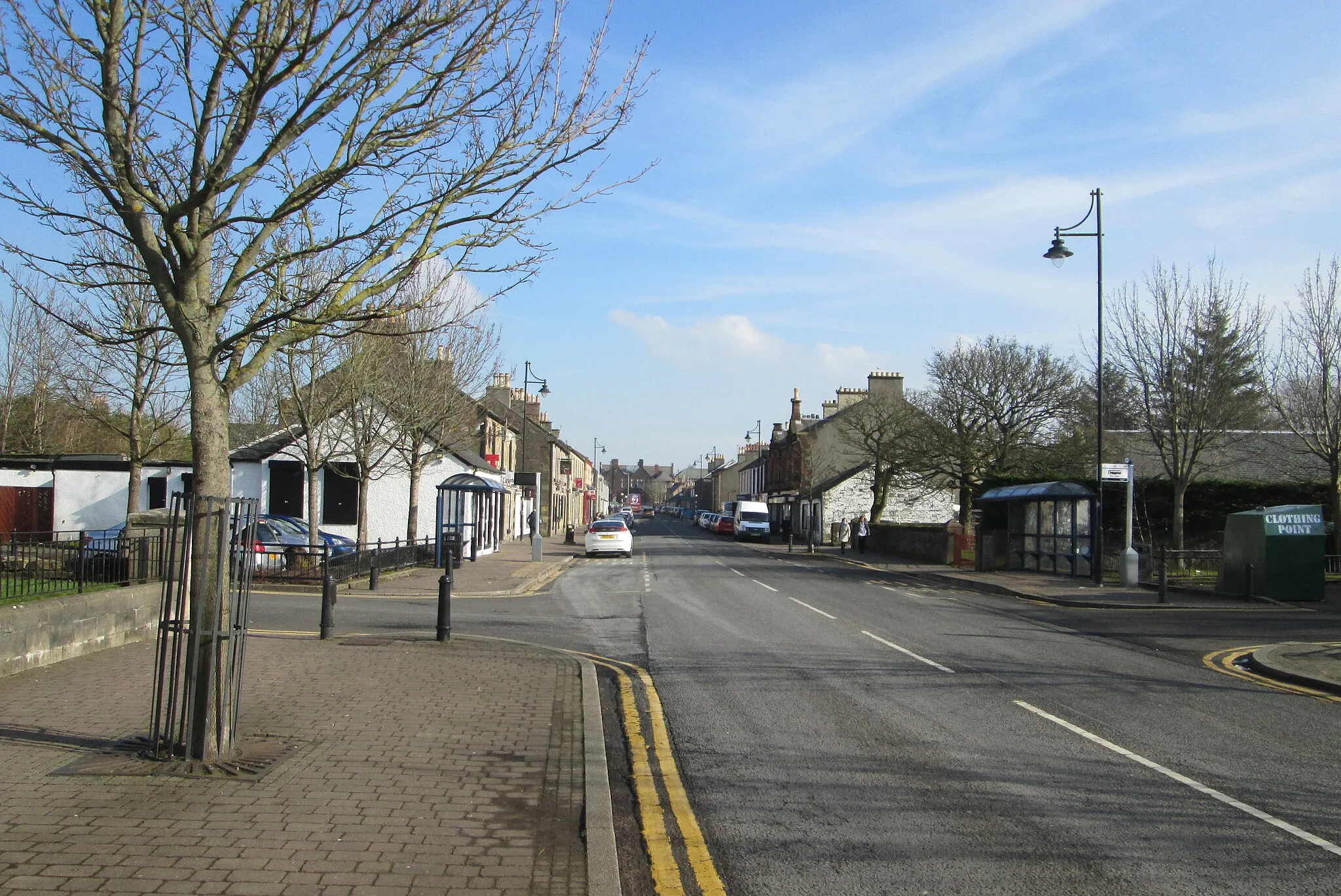 Photo showing: w:Dreghorn Main Street, looking east from Dreghorn and Springside Parish Church and the B7081 crossroads