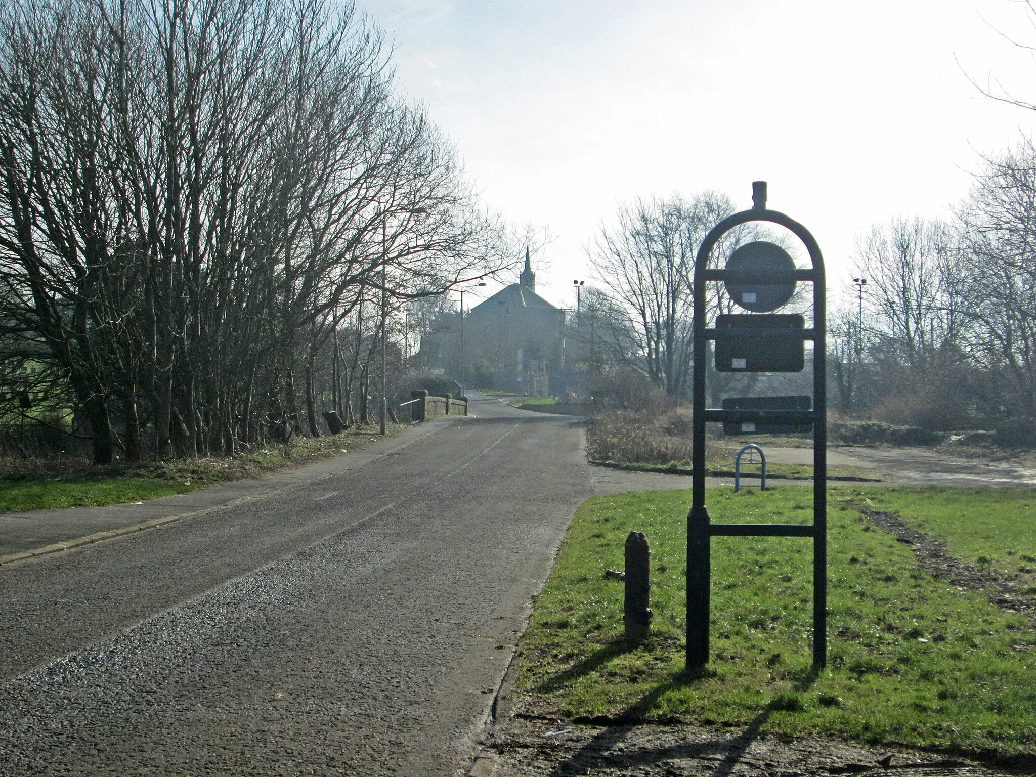 Photo showing: w:Dreghorn looking south up Station Brae over Dreghorn Bridge across the Annick Water to Dreghorn and Springside Parish Church. Taken from National Cycle Route 73 at the site of Dreghorn railway station