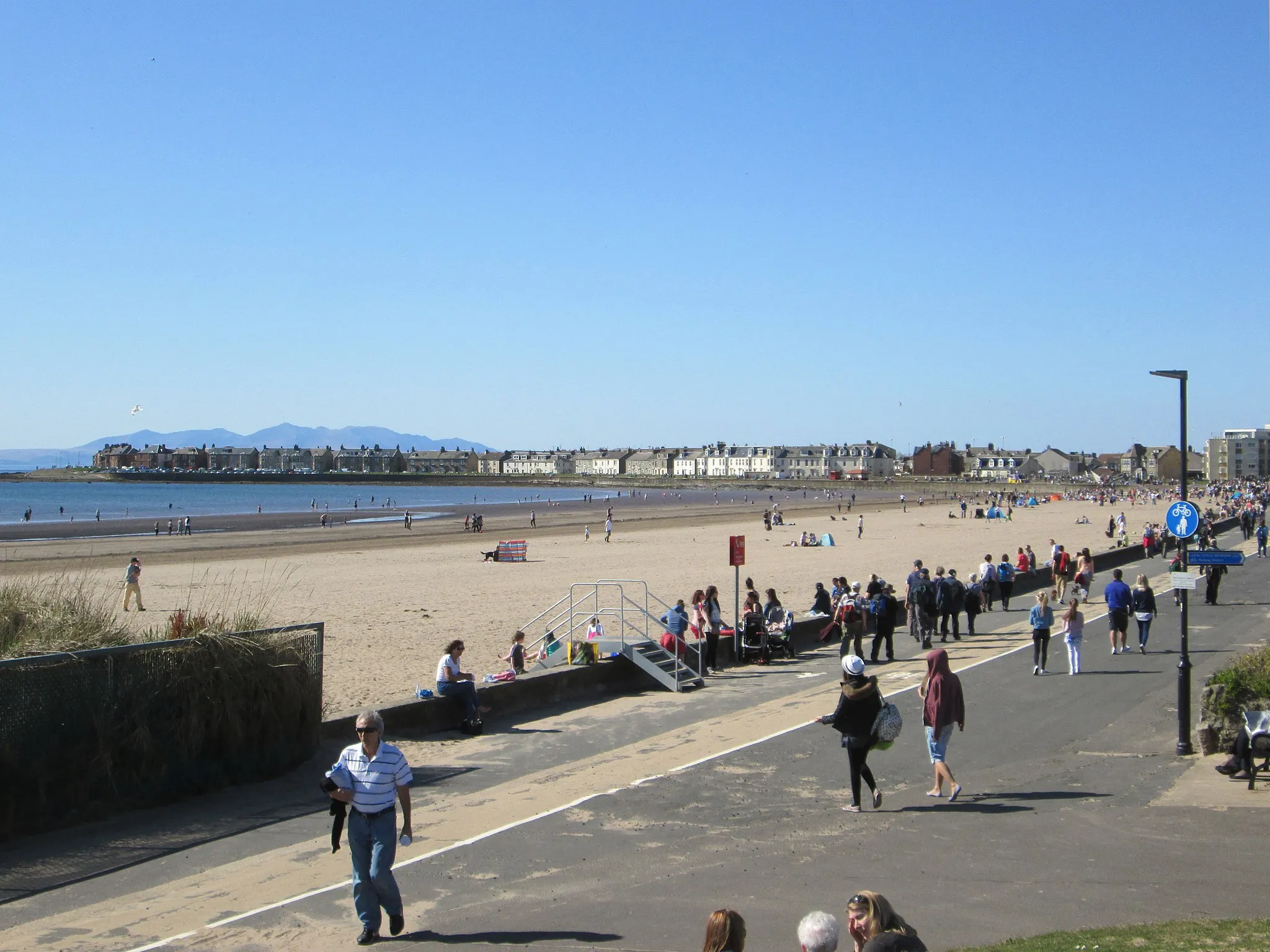 Photo showing: Troon esplanade, and beach on the Firth of Clyde, with the hills of the Isle of Arran visible behind the town.