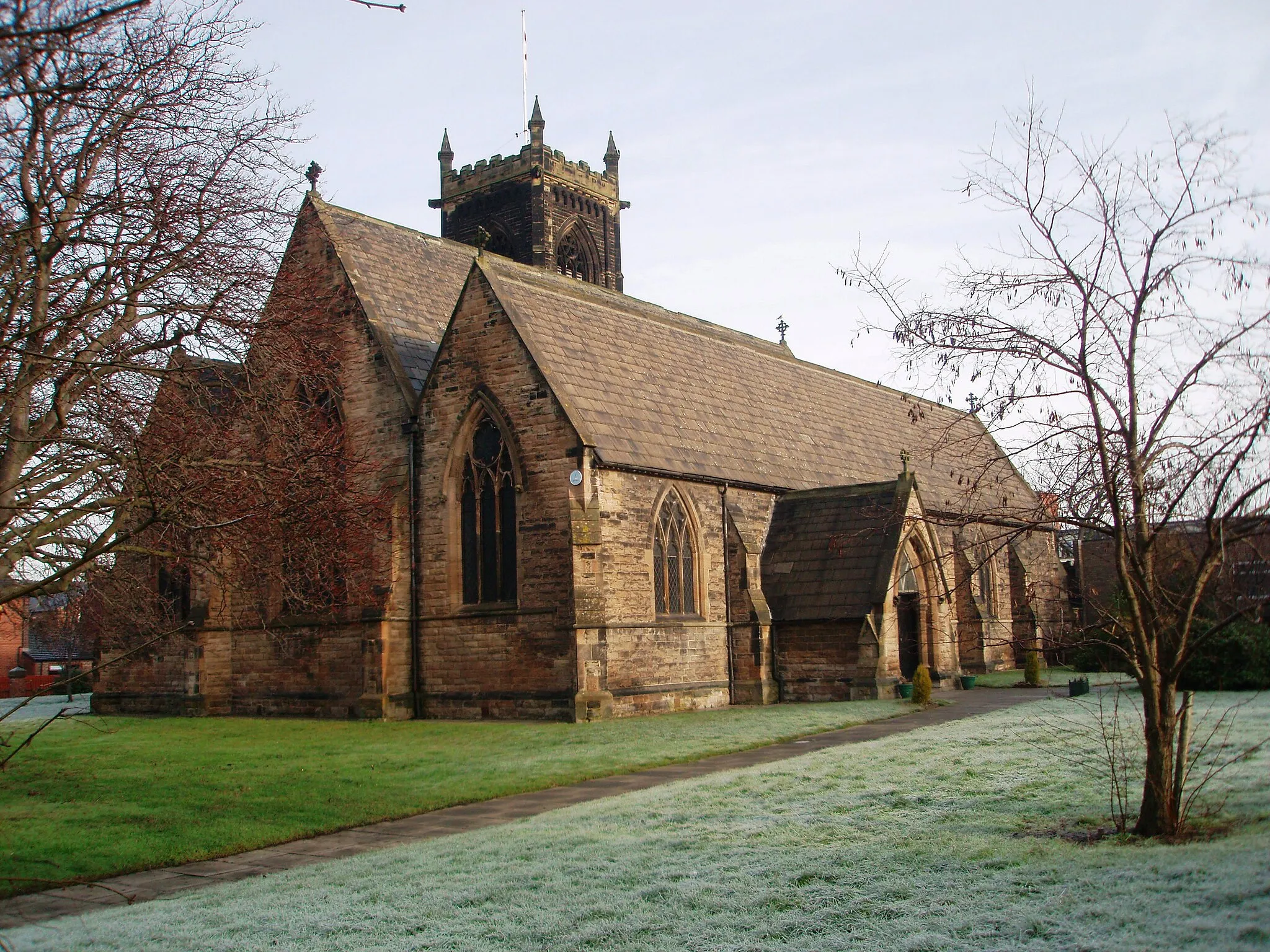 Photo showing: Church of St Paul the Apostle, Thornaby This photograph of the church in North Thornaby was taken from just inside the church grounds near the junction of Cambridge Road with Thornaby Road (A1045). Notice the two different 'colors' of the grass: that on the right has an early-morning frost while that on the left has thawed out.