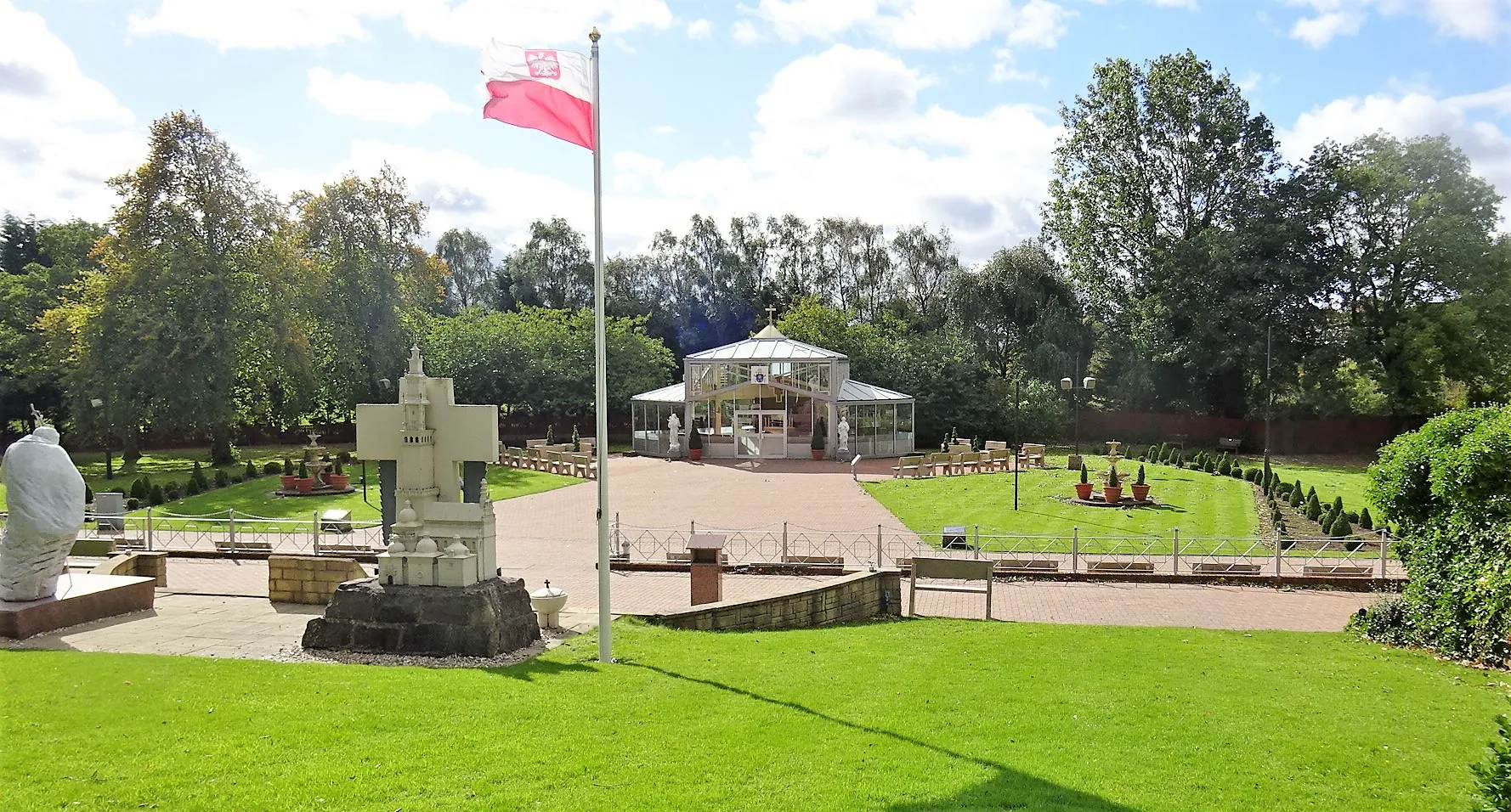 Photo showing: In the distance. Our Lady, Maid of the Seas, Glass Chapel, Carfin Grotto, North Lanarkshire, Scotland. The chapel came from the Glasgow Garden Festival.