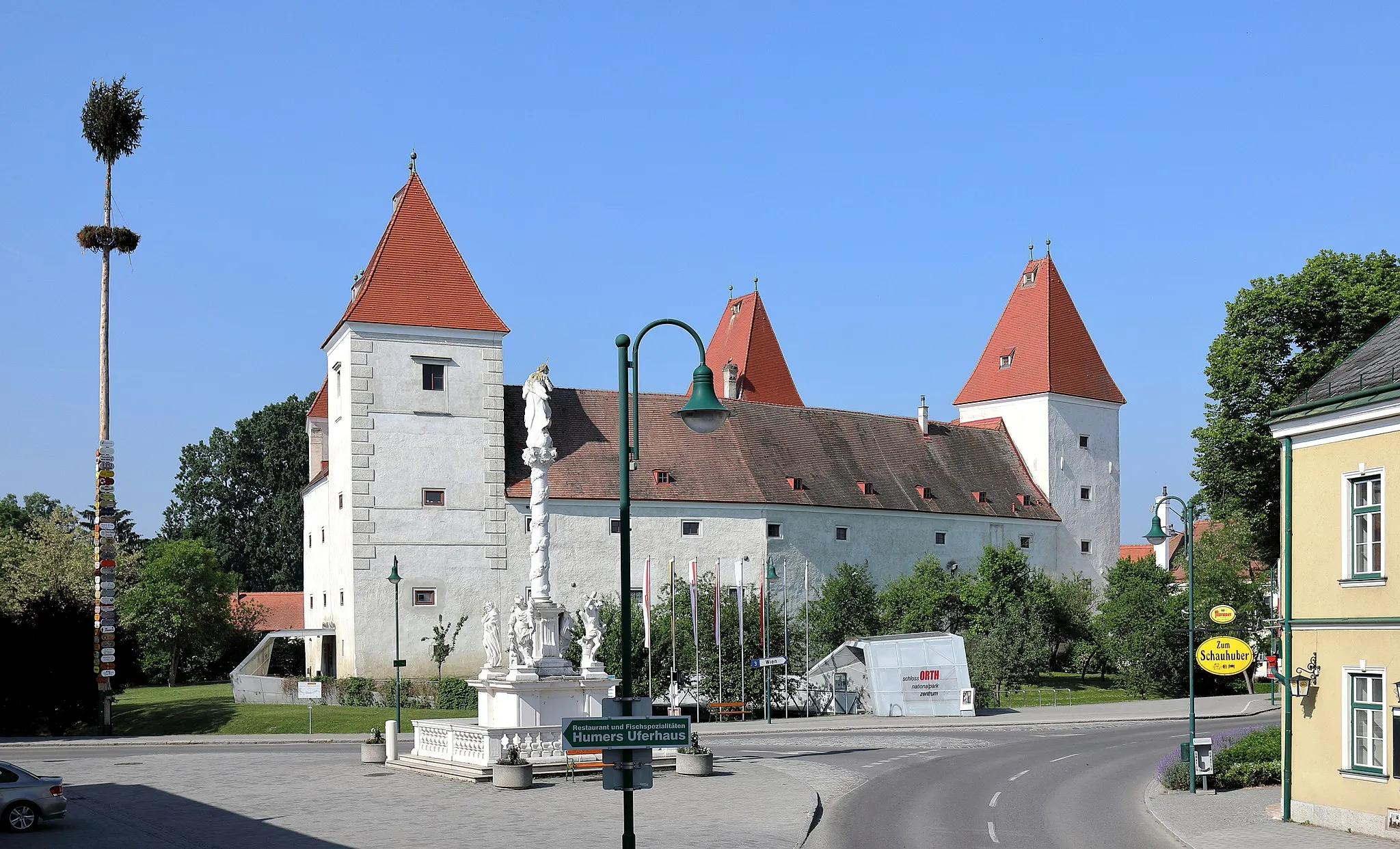 Photo showing: Das Ortszentrum der niederösterreichischen Marktgemeinde Orth an der Donau. Links der Maibaum, im Zentrum das Schloss Orth, das als Besucherzentrum des Nationalparkes Donau-Auen dient und davor die Mariensäule.