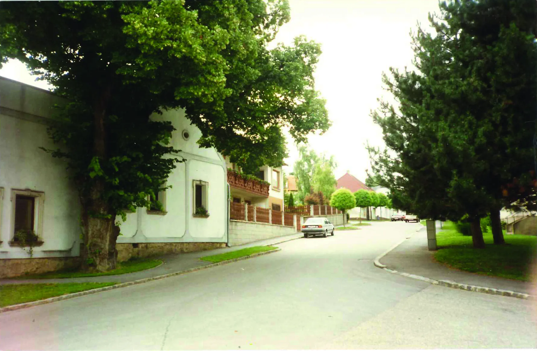 Photo showing: Kaisersteinbruch Hauptstrasse, li. das ehemalige Dreißigstamt von 1708. (Das Haus ist wesentlich älter) Das Bild stammt aus den 1990er Jahren, da standen diese Bäume noch. Mittlerweile umgeschnitten.