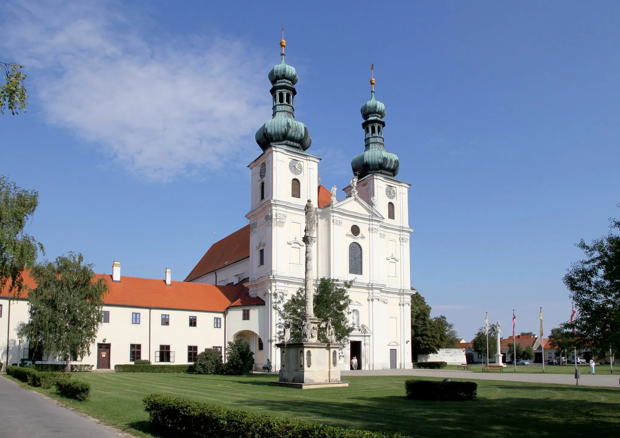 Photo showing: Die Basilika Mariä Geburt in der burgenländischen Stadt Frauenkirchen. Im Vordergrund die Mariensäule und links ein Gebäude des Franziskanerklosters.