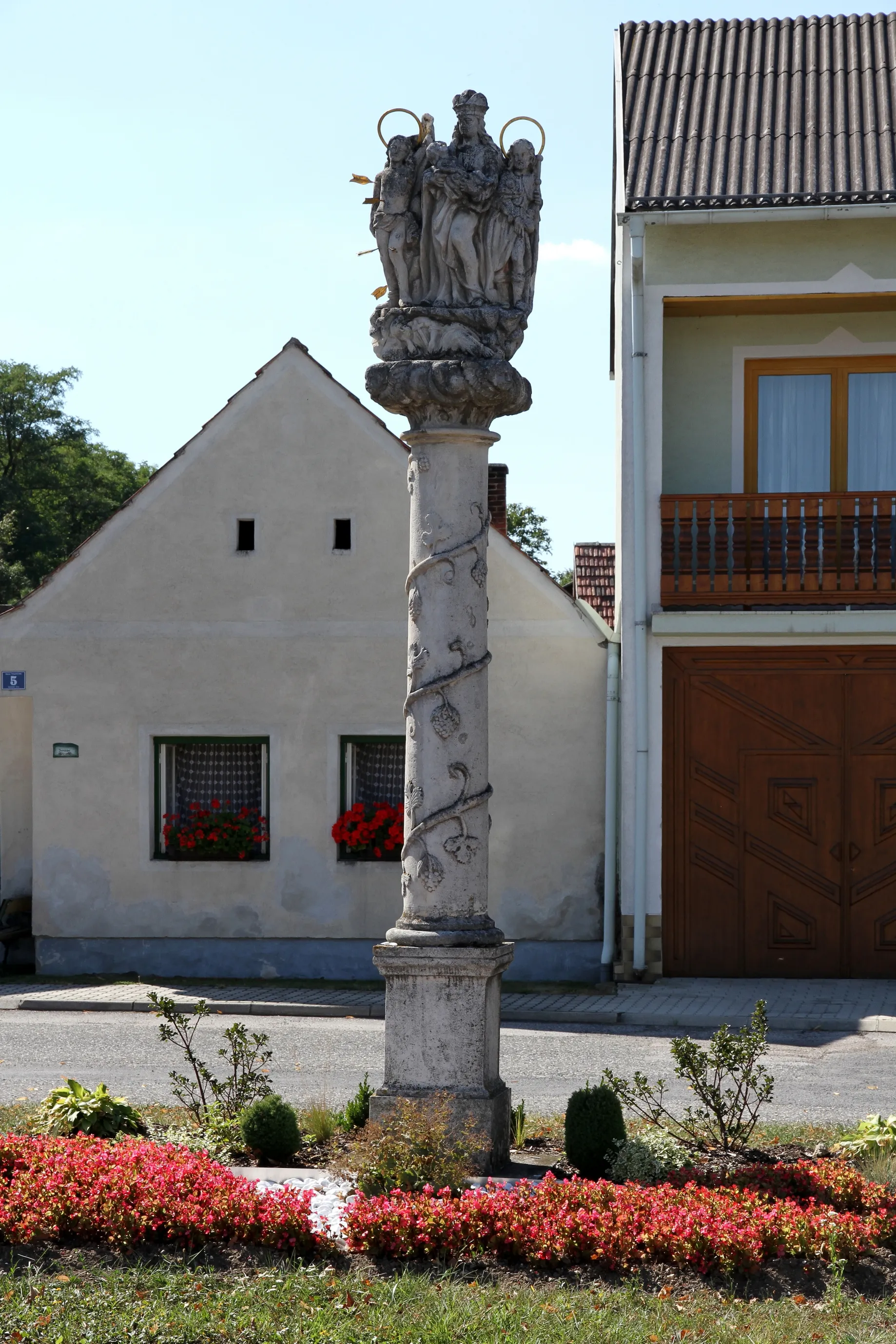 Photo showing: Pestsäule am Anger in der burgenländischen Gemeinde Großwarasdorf. Eine Weinlaubsäule aus der ersten Hälfte des 18. Jahrhunderts mit den Steinfiguren Maria und den Heiligen Sebastian und Rochus.