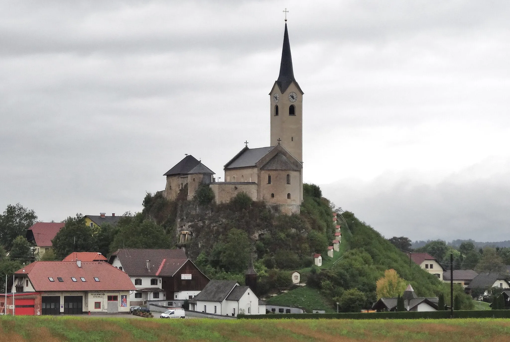 Photo showing: Das Kirchenensemble in Stein im Jauntal. Übersicht mit Friedhofskirche, Kärntner Kreuzweg und Pfarrkirche