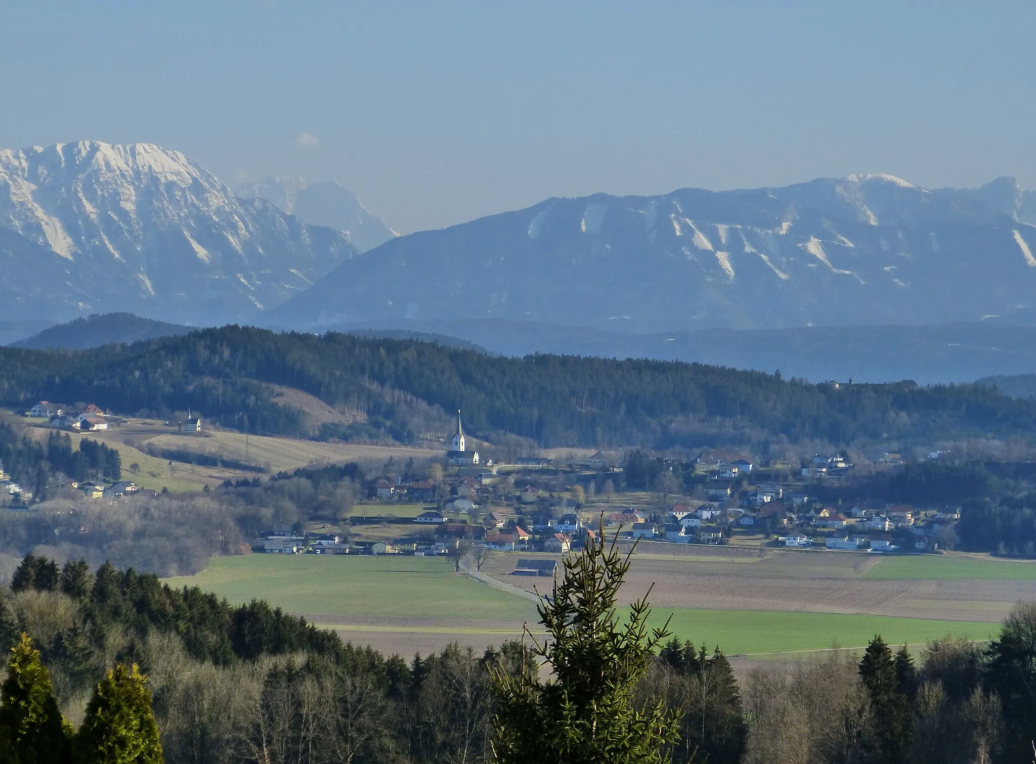 Photo showing: Bildmitte: Hörzendorf (Gemeinde Sankt Veit an der Glan, Kärnten). links davon Filialkirche Streimberg. rechts teilweise verdeckt: Tanzenberg. Im Hintergrund: Obir.