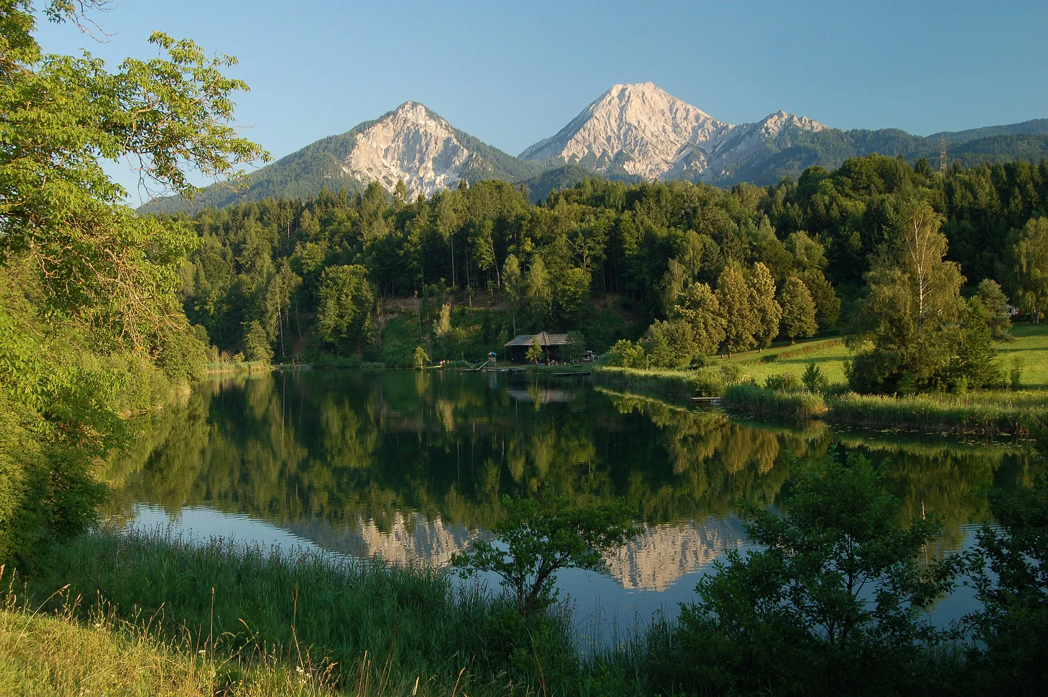 Photo showing: Ferlacher Spitze (1742m), Mittagskogel (Kepa, 2145m) and Kleiner Mittagskogel (1815m) with Lake Aichwaldsee in the foreground, Carinthia, Austira.