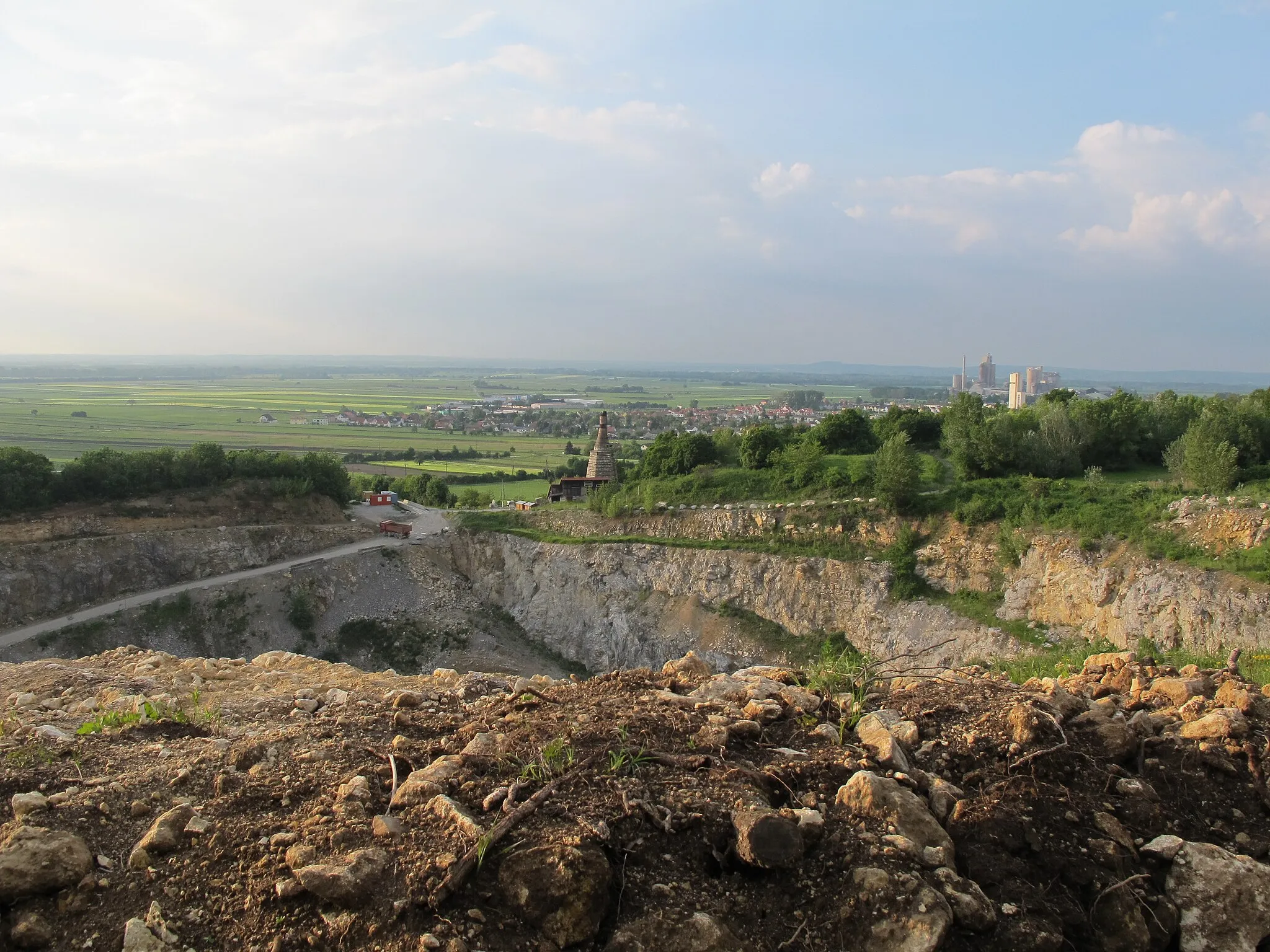 Photo showing: Cava near the village Mannersdorf am Leithagebirge / Lower Austria / Austria / EU. In the foreground is the quarry in the middle of the chimney of the kiln Baxa is visible in the background, the level of the village "Mannersdorf".