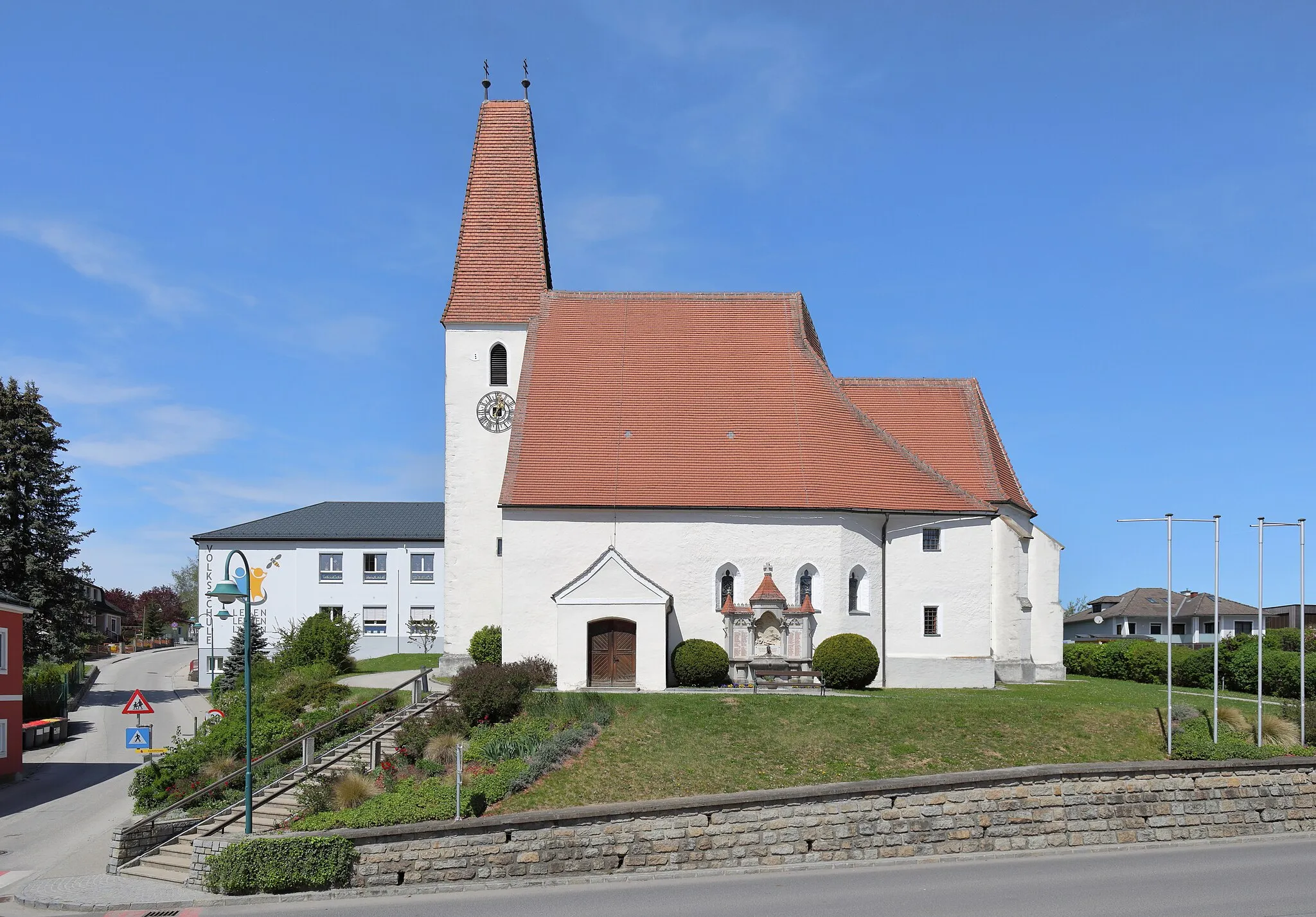 Photo showing: Ortszentrum der niederösterreichischen Marktgemeinde Zeillern mit der röm.-kath. Pfarrkirche hl. Jakobus der Ältere und links im Hintergrund die Volksschule. Die Pfarrkirche, eine spätgotische Staffelkirche mit einem steilen Satteldach und eingezogenem Chor, wurde mehrmals umgebaut und von 1889 bis 1899 regotisiert. Der vorgestellte Westturm stammt aus dem 14. Jahrhundert und das steile Keildach wurde im 19. Jahrhundert aufgesetzt.