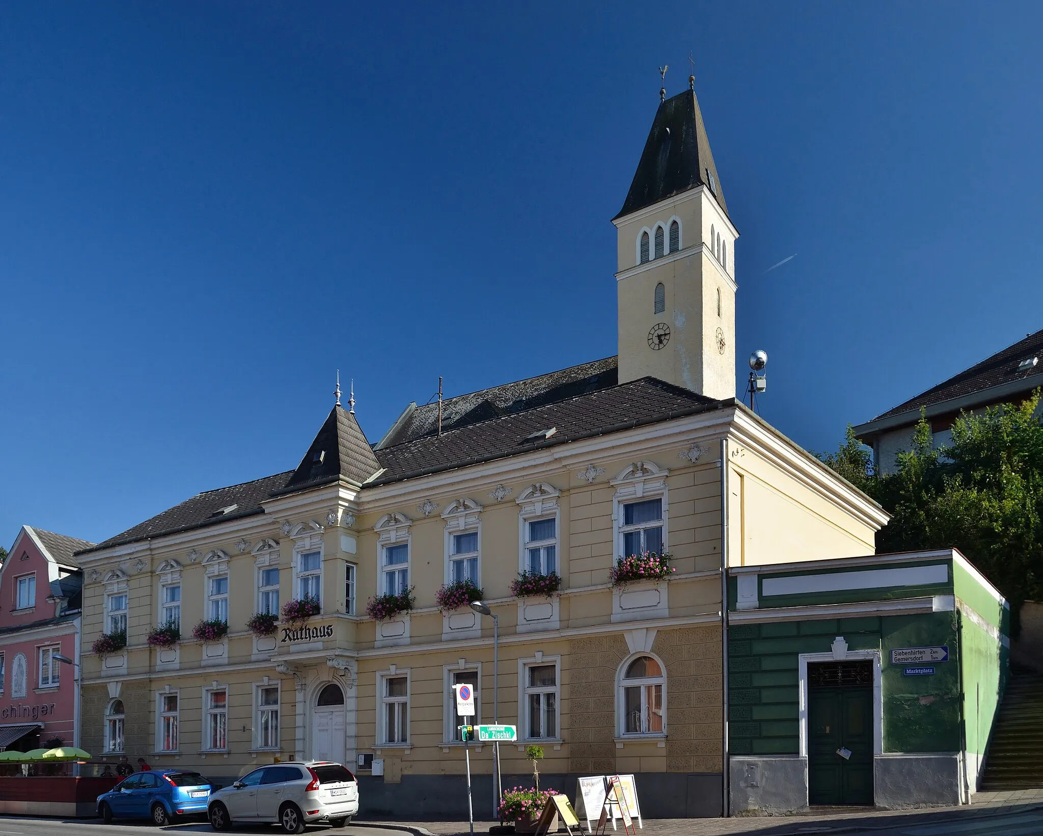 Photo showing: The town hall / municipal office of Böheimkirchen, Lower Austria, originates from the beginning of the 20th century and is protected as a cultural heritage monument. In the background the parish church St. James the Greater, which is also protected.