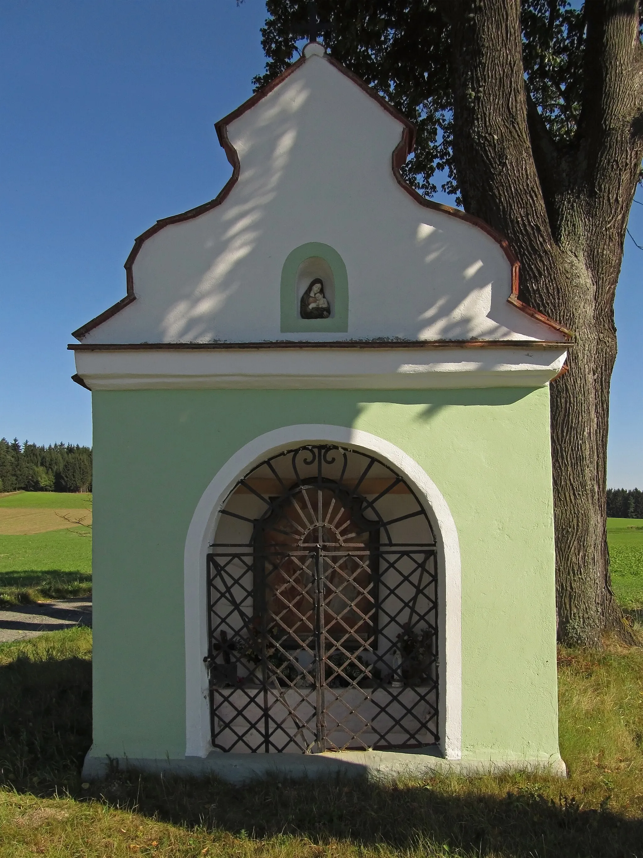 Photo showing: Die nachbarocke, wahrscheinlich in der ersten Hälfte des 19. Jahrhunderts errichtete Wegkapelle am östlichen Ortsende hat eine Putzgliederung und einen geschwungenen Giebel.