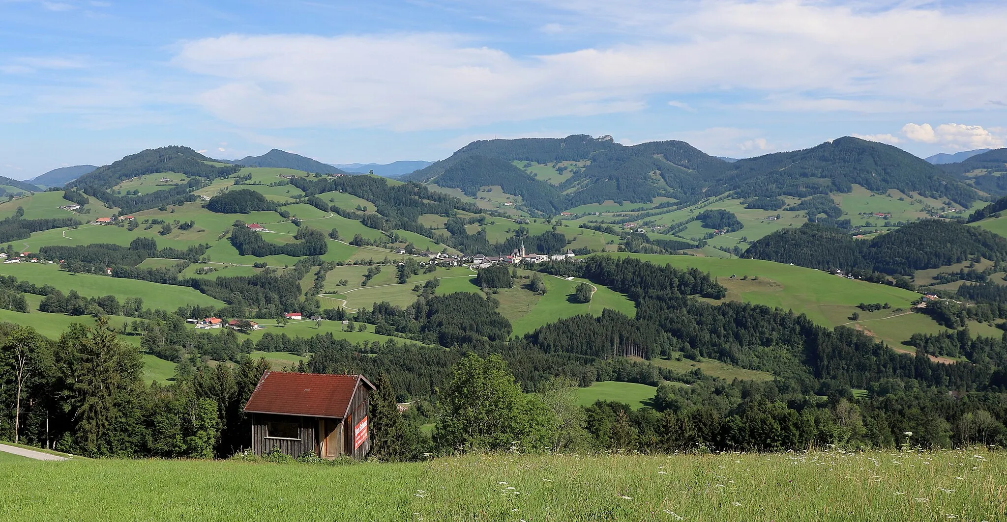 Photo showing: Nordwestansicht des Gemeindegebietes der oberösterreichischen Gemeinde Maria Neustift. Standort ist der Glasenberg in Buchschachen, ein Ortsteil von Maria Neustift. In der Bildmitte der Ort Maria Neustift und im Hintergrund der 1084 m hohe Lindauer Berg mit der markanten 1103 m hohen Lindaumauer. Rechts im Bild der 1042 m hohe Halsberg und in der linken Bildhälfte im Vordergrund der 958 m hohe Freithofberg sowie dahinter die 1066 m hohe Spindeleben.