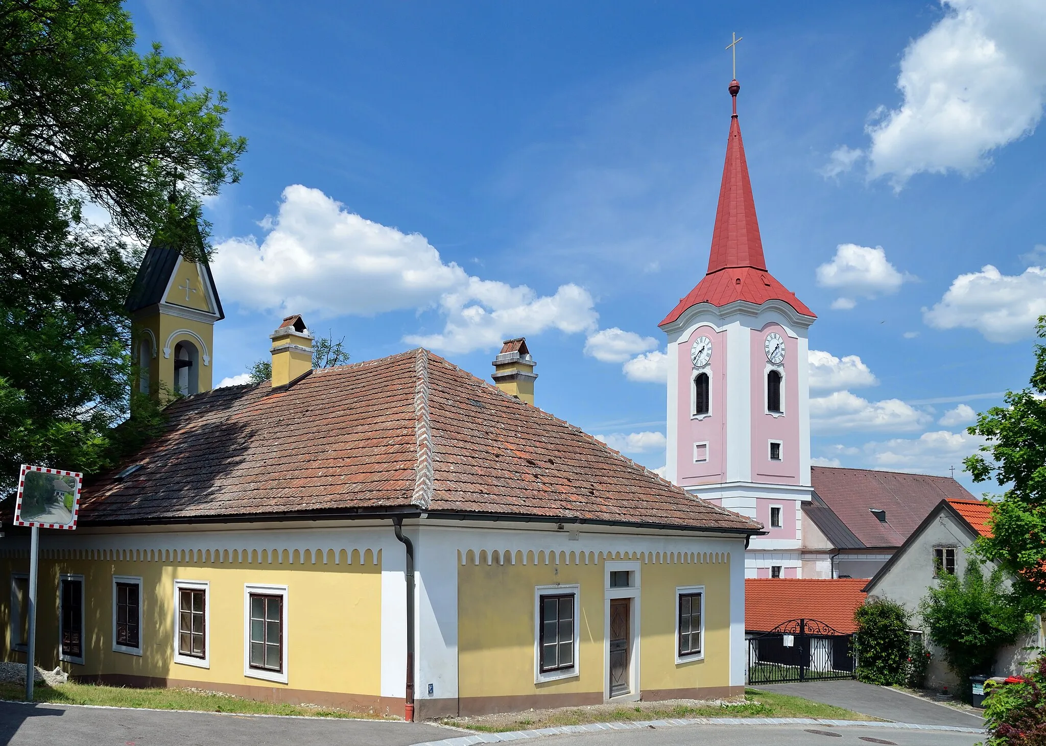 Photo showing: A building in Althanstraße 9, Murstetten, municipality of Weißenkirchen an der Perschling, Lower Austria. In the rear the parish church Verklärung Christi.