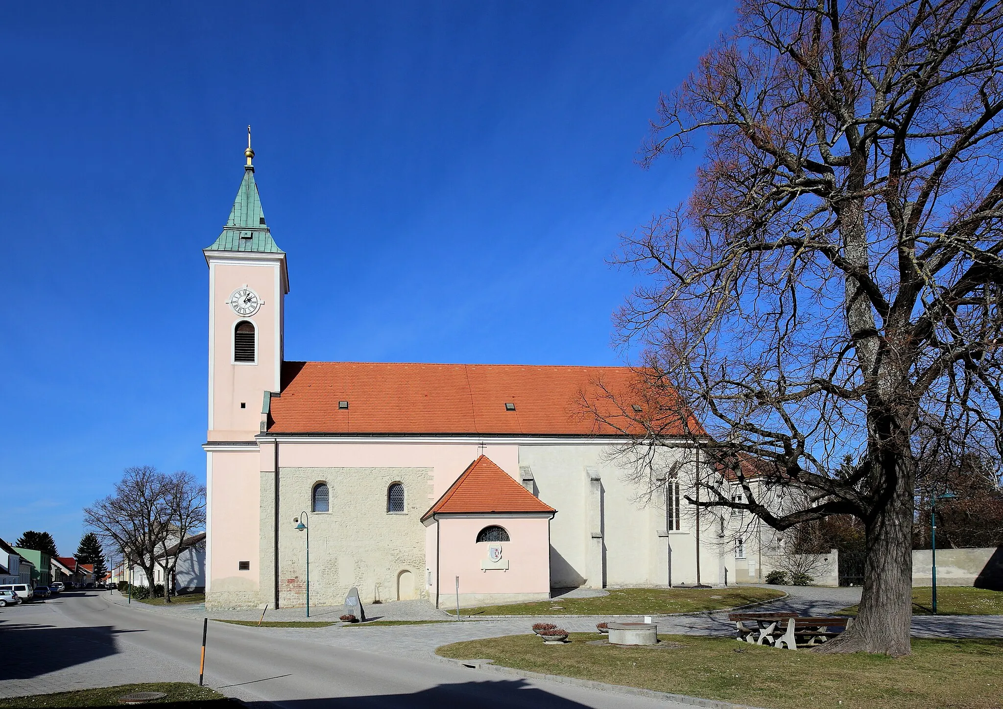 Photo showing: Südansicht der katholischen Pfarrkirche hl. Stephan in Probstdorf, ein Ortsteil der niederösterreichischen Stadt Groß-Enzersdorf. Ein Sakralbau, dessen Langhaus in der Kernsubstanz mittelalterlich ist. In der 2. Hälfte des 17. Jahrhunderts wurde der Kirchenbau barockisiert und im Süden sowie im Norden je ein Kapellenanbau errichtet. Der vorgestellte Turm im Westen stammt aus dem Jahr 1802. Der gotische Chor und die Sakristei im Norden sind mit 1418 datiert.