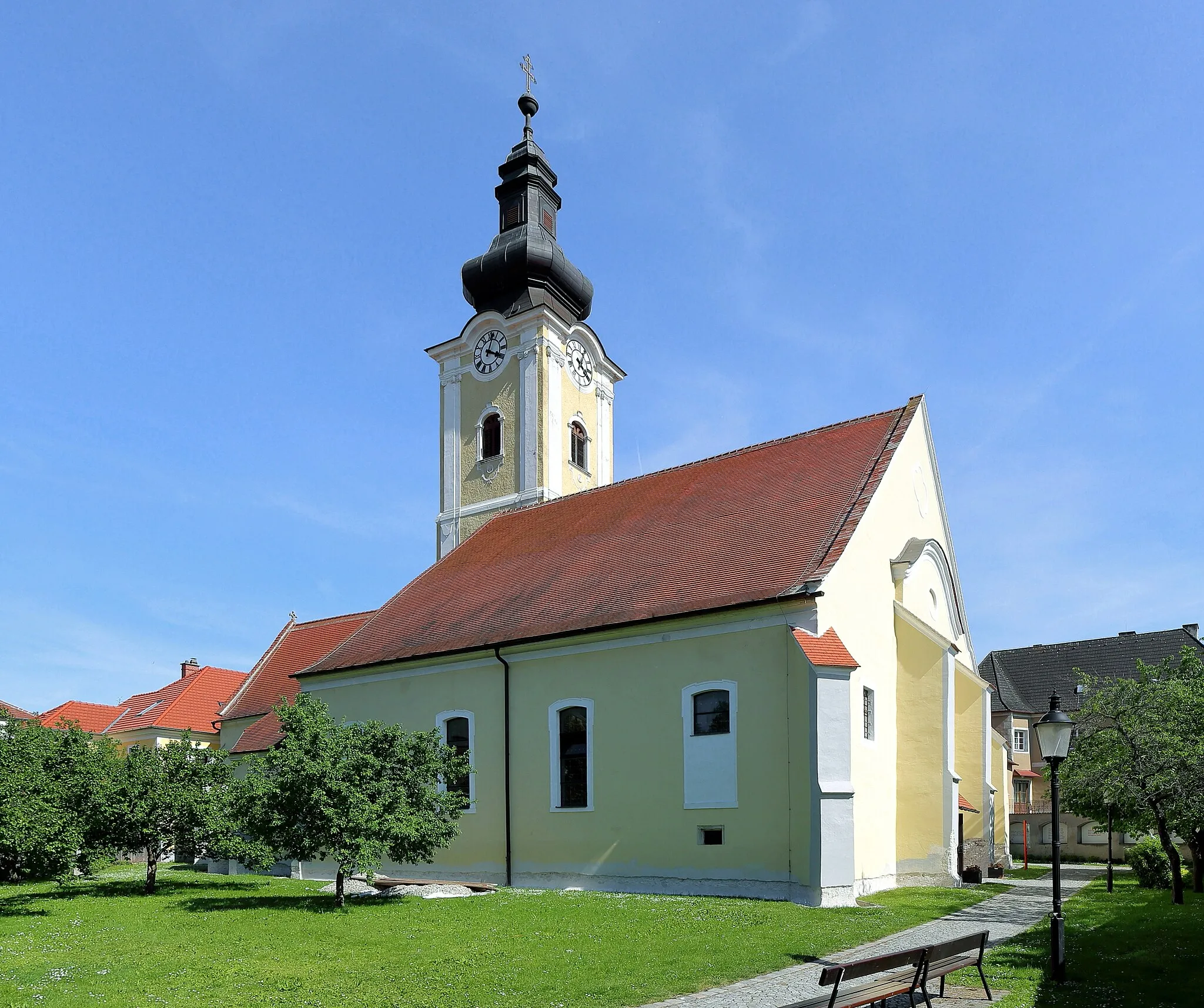 Photo showing: Nordwestansicht der römisch-katholischen Pfarrkirche hl. Stefan in der niederösterreichischen Stadt Mautern an der Donau. Die Kirche wurde in der zweiten Hälfte des 14. Jahrhunderts errichtet, wobei die nördliche Chorseitenkapelle (Totenkapelle) älteren Bestandes ist (Ende 14. Jahrhundert). In den Jahren 1695/96 baute Carlo Antonio Carlone das Langhaus innen um und barockisierte es. Der mächtige, dreigeschossige Kirchturm im südlichen Chorwinkel wurde über mittelalterlichen Kern von 1774 bis 1777 von dem Baumeister Karl Ehmann errichtet.