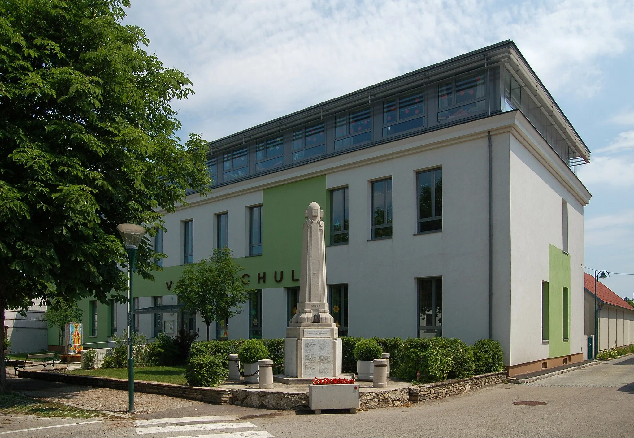 Photo showing: Primary School (Volksschule) in Pfaffstätten in Lower Austria with the war memorial just in front.
