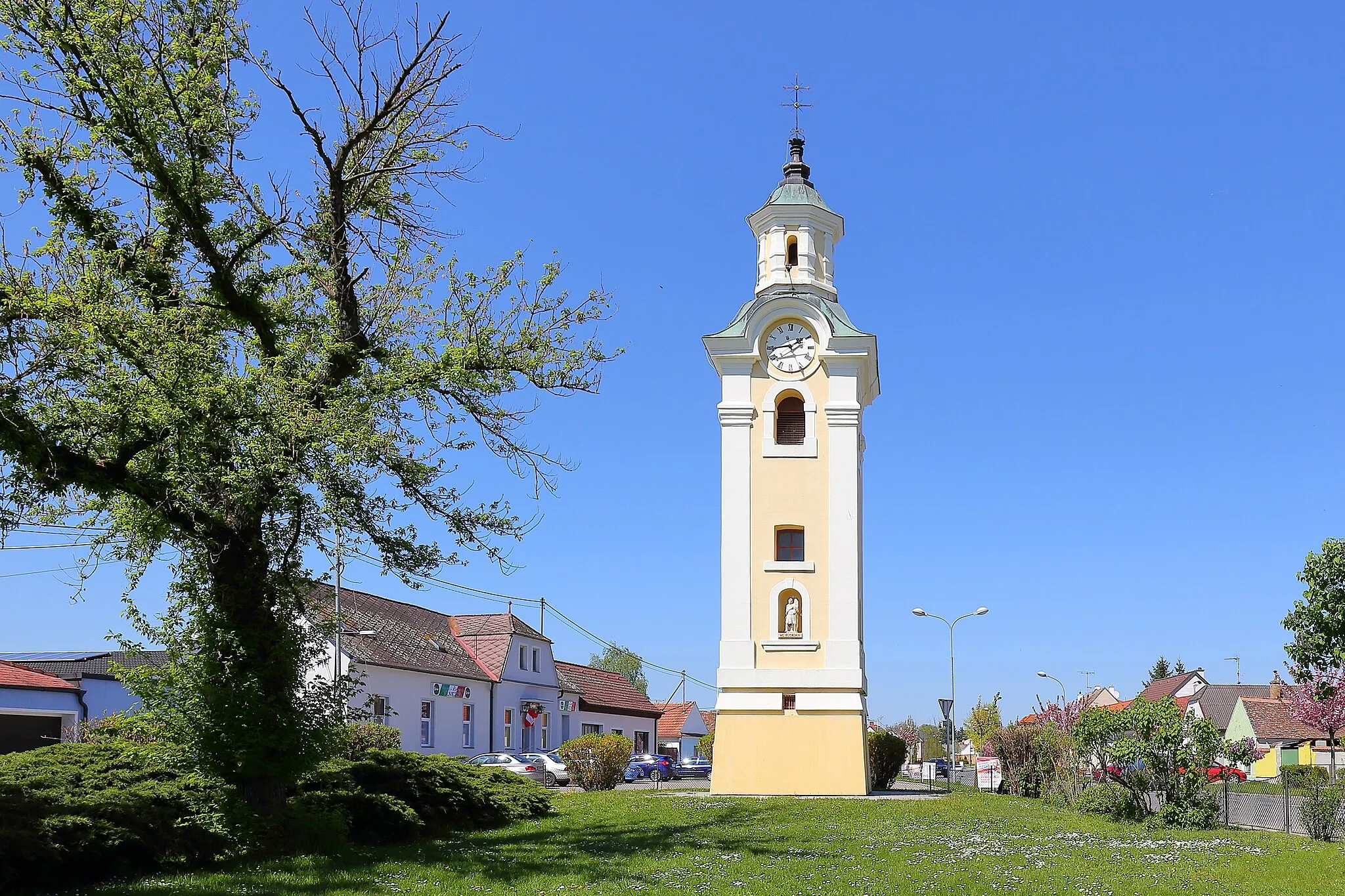 Photo showing: Südansicht des Glockenturmes und Wahrzeichen der niederösterreichischen Marktgemeinde Hohenau an der March. Der dreigeschossige Glockenturm mit quadratischen Grundriß wurde ursprünglich nächst Hauptstraße/Schulgasse 1745 errichtet und 1966/68 an jetziger Stelle versetzt.