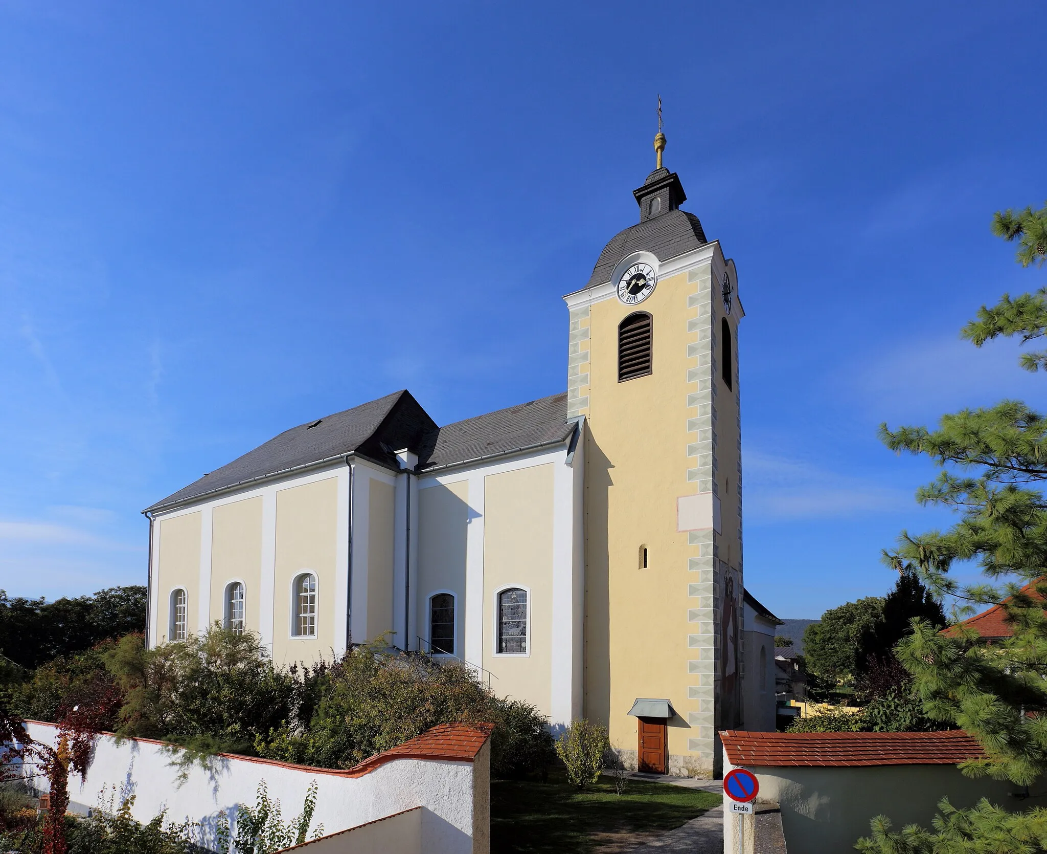 Photo showing: Südostansicht der römisch-katholischen Pfarrkirche hl. Jakobus d. Ä. in der niederösterreichischen Gemeinde Weikersdorf am Steinfelde. Ursprünglich eine romanische Chorquadratkirche aus der ersten Hälfte des 13. Jahrhundert, deren Kernsubstanz noch vorhanden ist. In der ersten Hälfte des 14. Jahrhunderts Bau des Turmes über dem Chorquadrat. Im 15./16. Jahrhundert wurde nordseitig die Annenkapelle errichtet, die seit 1753 als Sakristei dient. Unter dem Wiener Domherr Franz Zeißler erfolgte 1753 ein Um- und teilweiser Neubau. So wurde unter anderem das dreijochige Langhaus errichtet, der Chor erhöht und der Turm um eine Glockenstube aufgestockt sowie ein barocker Turmhelm aufgesetzt.