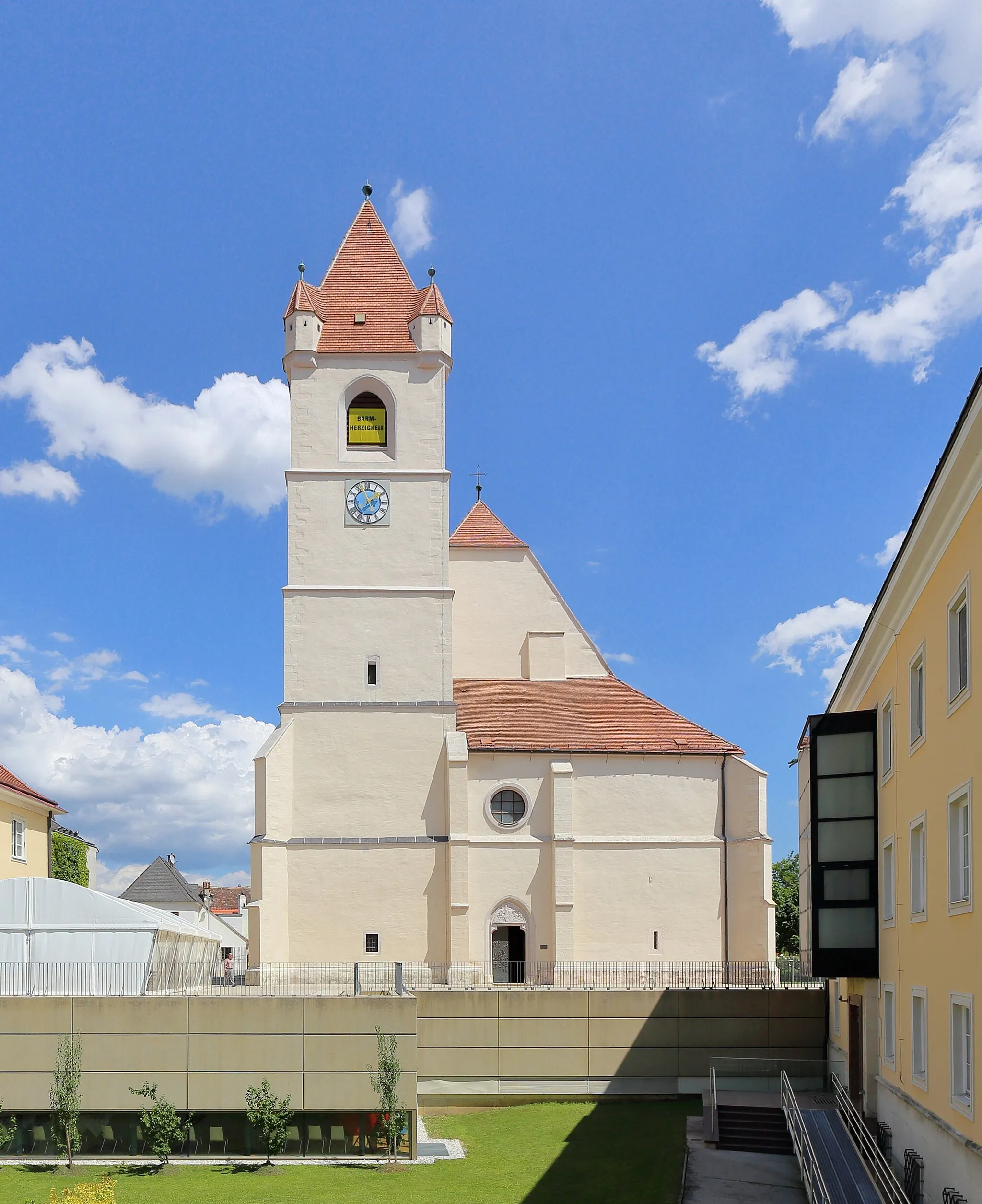 Photo showing: Westansicht des Domes St. Martin in der burgenländischen Landeshauptstadt Eisenstadt. Die dreischiffige spätgotische Hallenkirche wurde anstelle einer romanischen Kleinkirche errichtet. Um 1460 erfolgte der Neubau unter Johann Sybenhirter; 1468 war der Chor fertiggestellt und 1522 das Langhaus mit dem Turm. 1960 erfolgte die Erhebung der Stadtpfarrkirche zum Bischofsdom. Ursprünglich war westseitig eine Doppelturmfassade geplant, jedoch ausgeführt wurde nur der nordseitige und südseitig wurde der Turm nur bis auf eine Höhe von etwa des Langhauses realisiert.