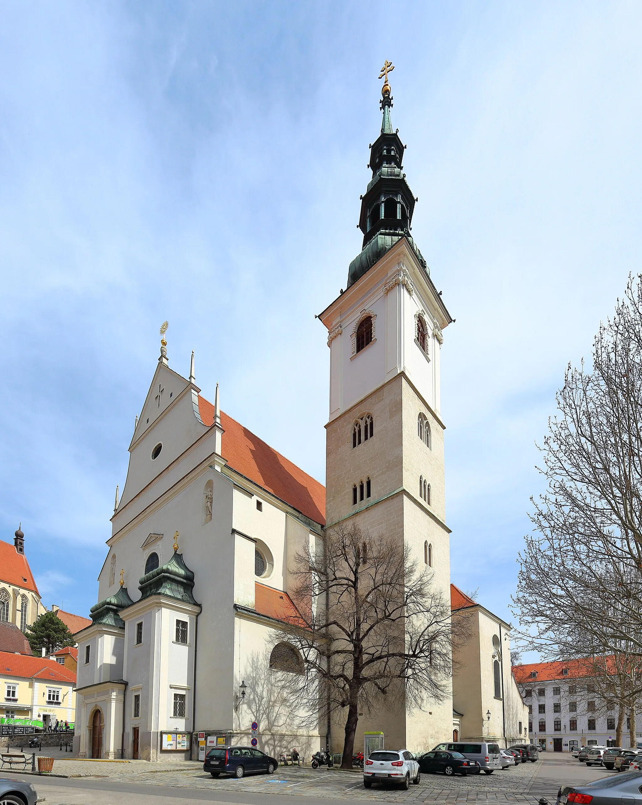 Photo showing: Südwestansicht der römisch-katholischen Pfarrkirche hl. Veit in der niederösterreichischen Stadt Krems an der Donau. Die Kirche wurde von 1616 bis 1630 nach Plänen der Baumeister Cypriano Biasino und Johann Baptist Spazio gebaut und war einer der ersten Barockkirchen nördlich der Alpen. Die Sakralbau besteht aus einem Langhaus mit acht Seitenkapellen, einem Querschiff und einem etwas niedrigeren Chor mit Rundapsis. Die Grabplatten an den Außenmauern erinnern an den ehemaligen alten Friedhof rund um die Kirche. In den Neubeu wurde teilweise der Turm der mittelalterlichen Vorgängerkirche miteinbezogen.